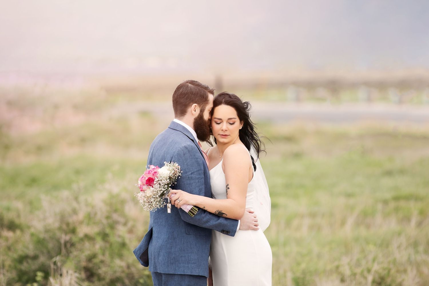 Sweet embrace during outdoor wedding photoshoot in natural mountain setting.
