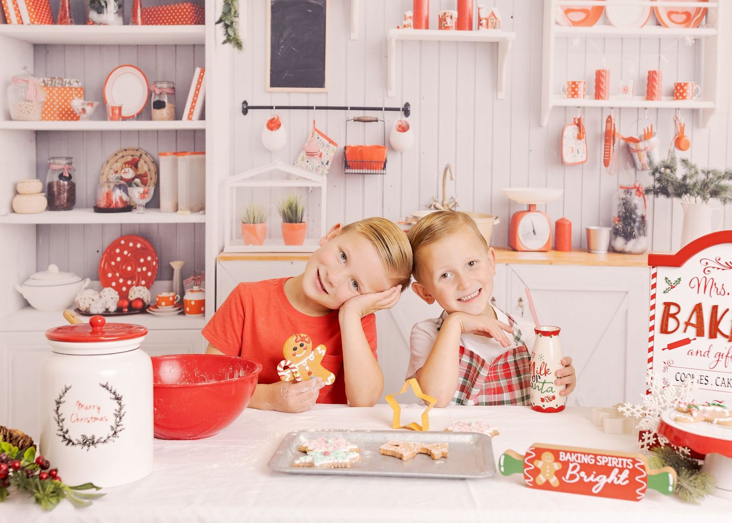 A festive holiday kitchen scene with white shelves displaying red and white decor, baking items, and Christmas decorations.