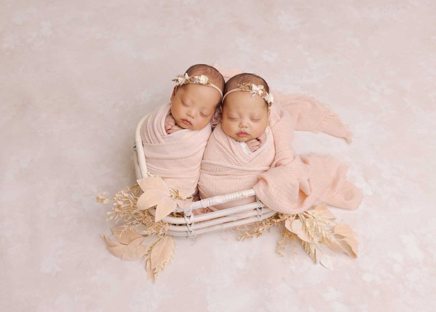 Row of seven soft pink newborn photography portraits showing sleeping babies on delicate blankets and lace backdrops.