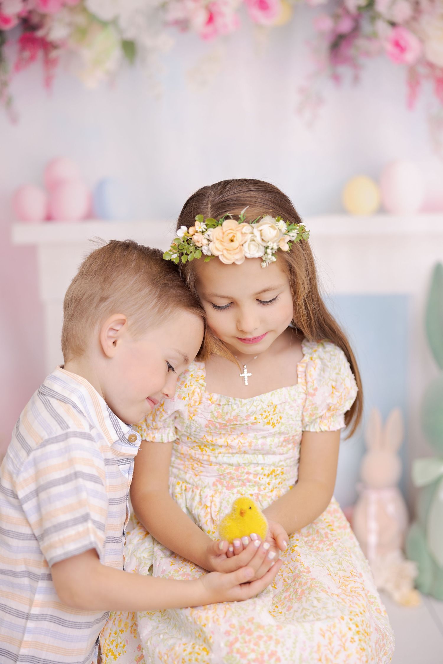 Sweet spring portrait session with soft pink floral backdrop and delicate floral crown details.