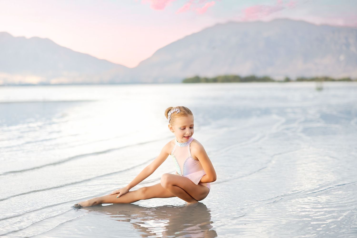 A dreamy sequence of photos showing a figure in white dress floating gracefully in serene ocean waters at sunset.