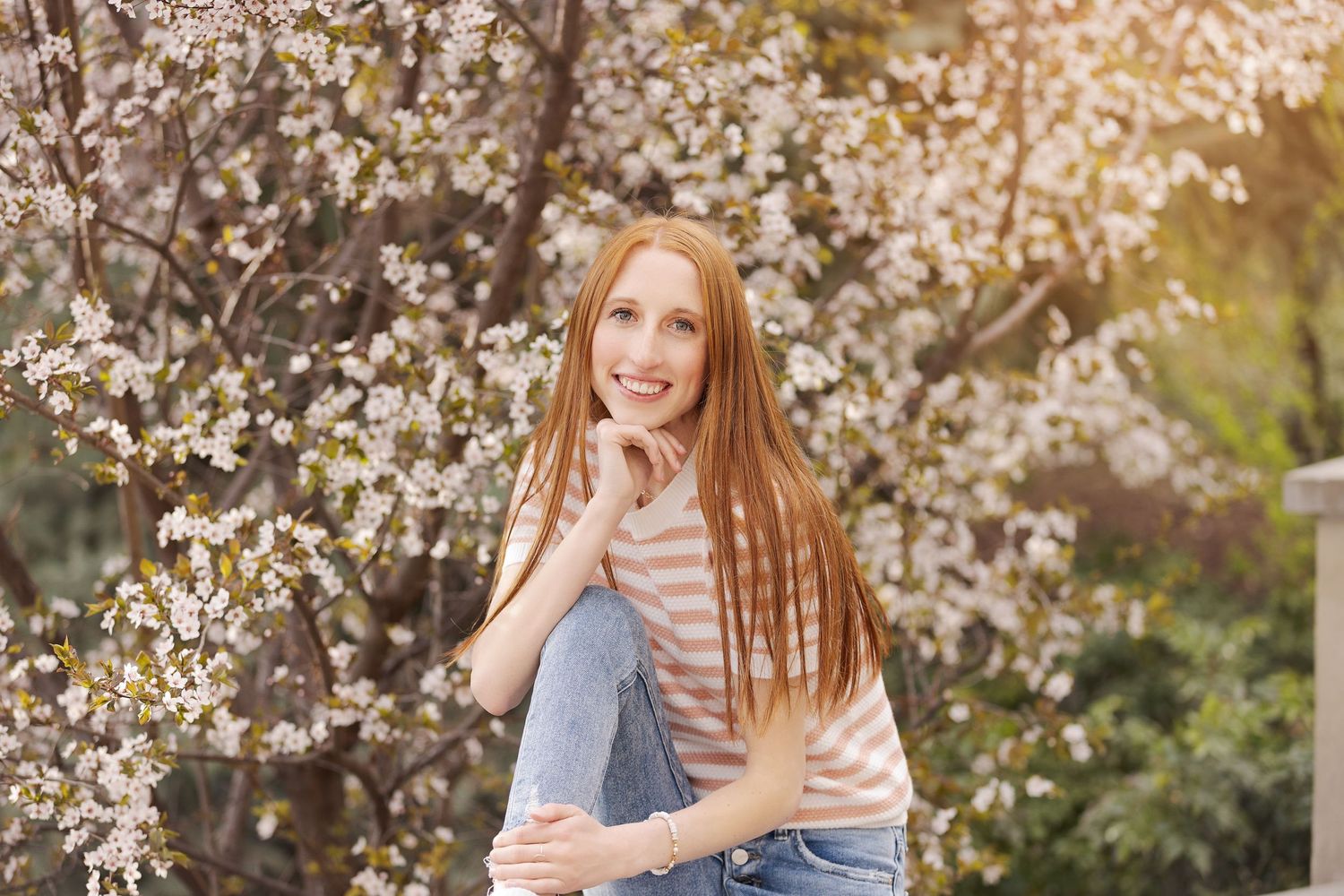 Spring portrait with cherry blossoms blooming in background.