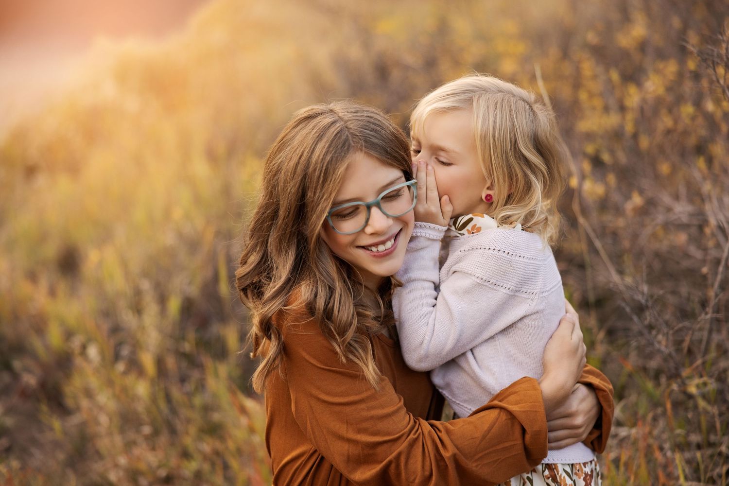Tender moment between parent and child against golden autumn background.
