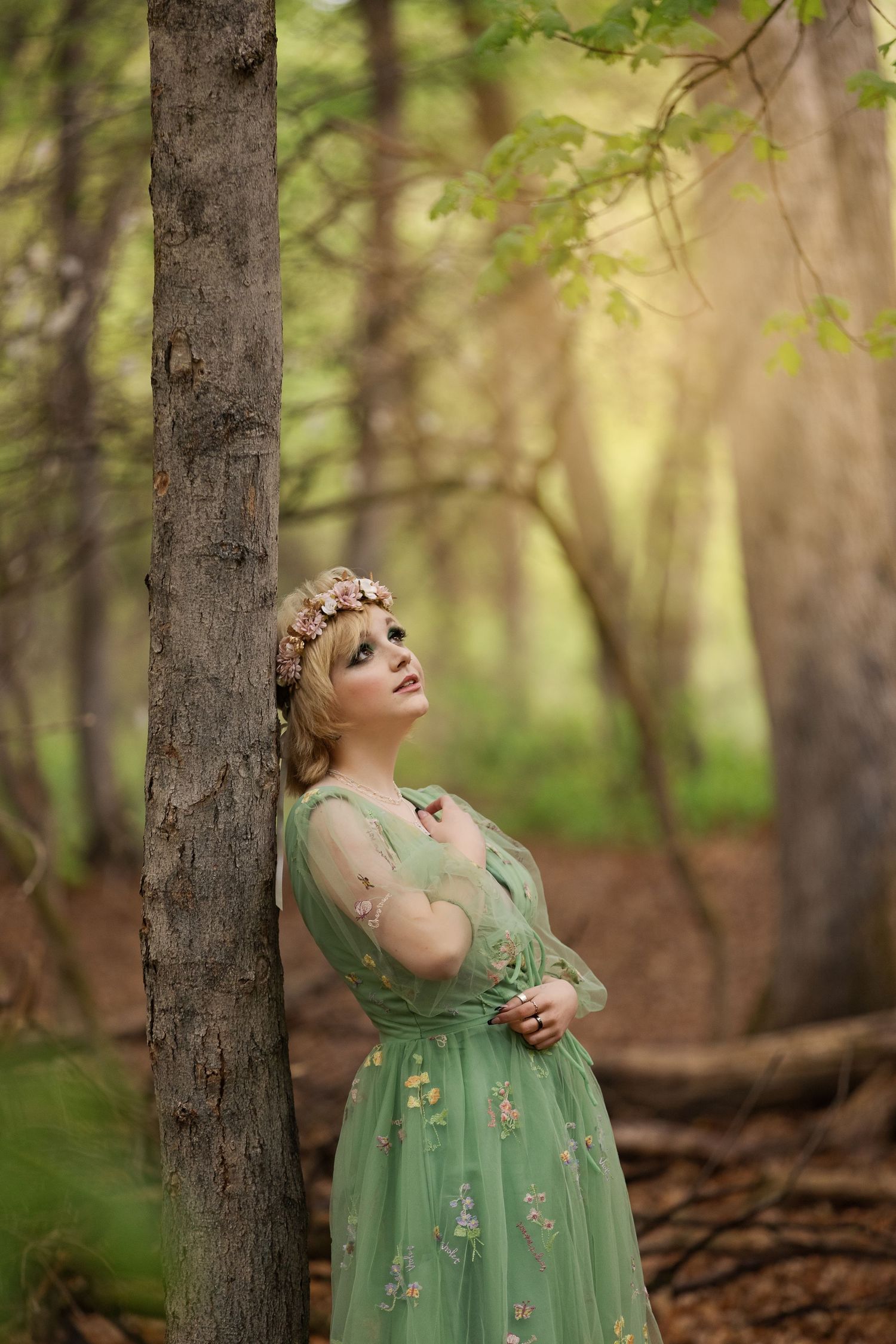 Dreamy forest scene with flowing mint green dress and floral headpiece.