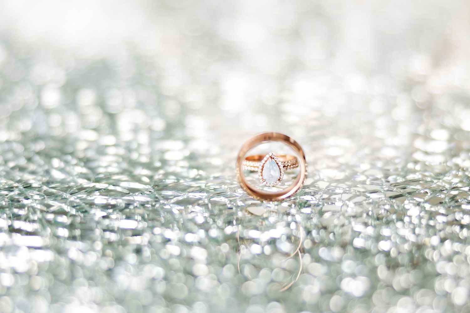 Rose gold wedding ring on a sparkly textured surface creates a dreamy macro photography composition.
