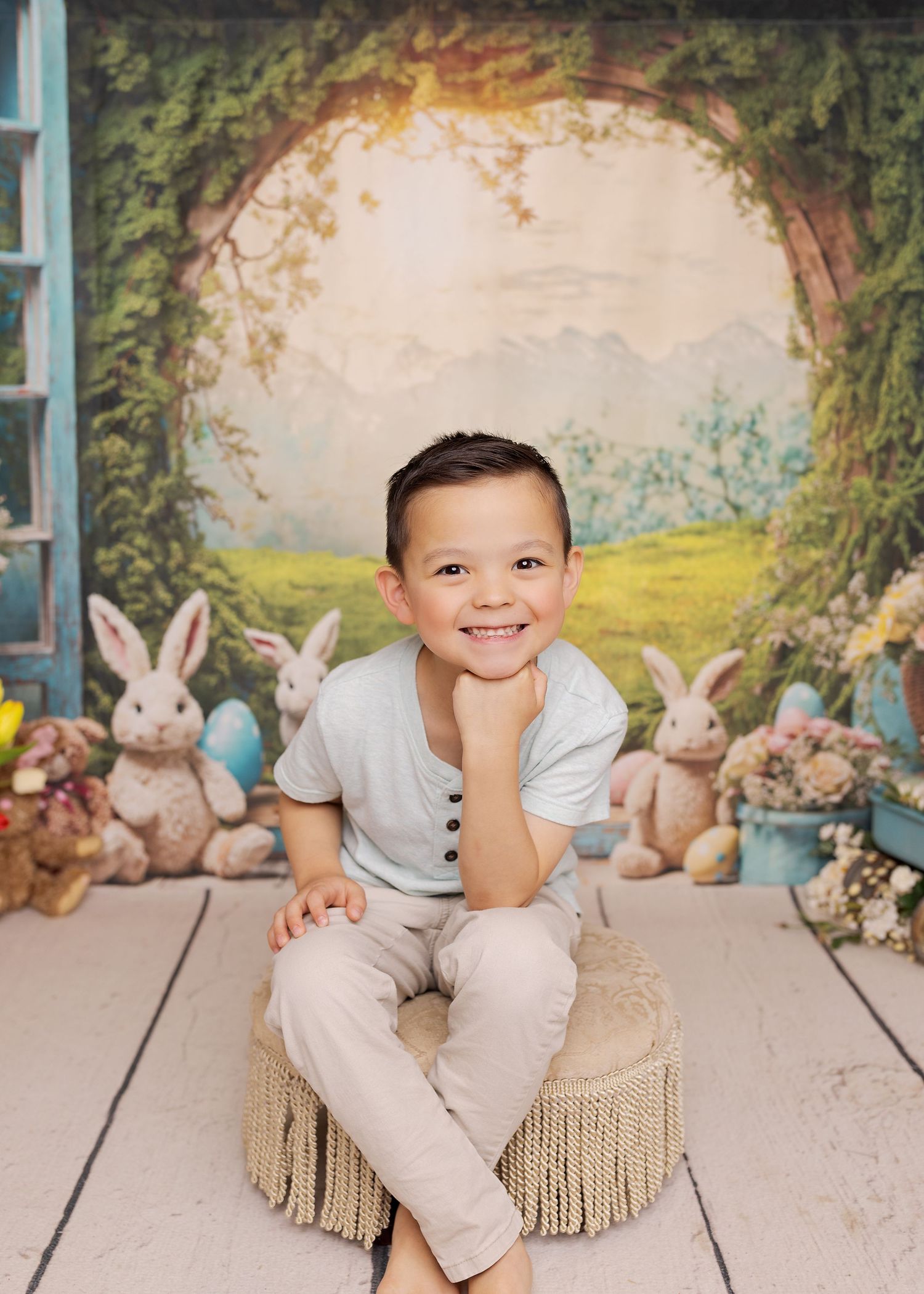 Sweet Easter photo session with plush bunnies and soft decor on wooden floor against dreamy garden backdrop.