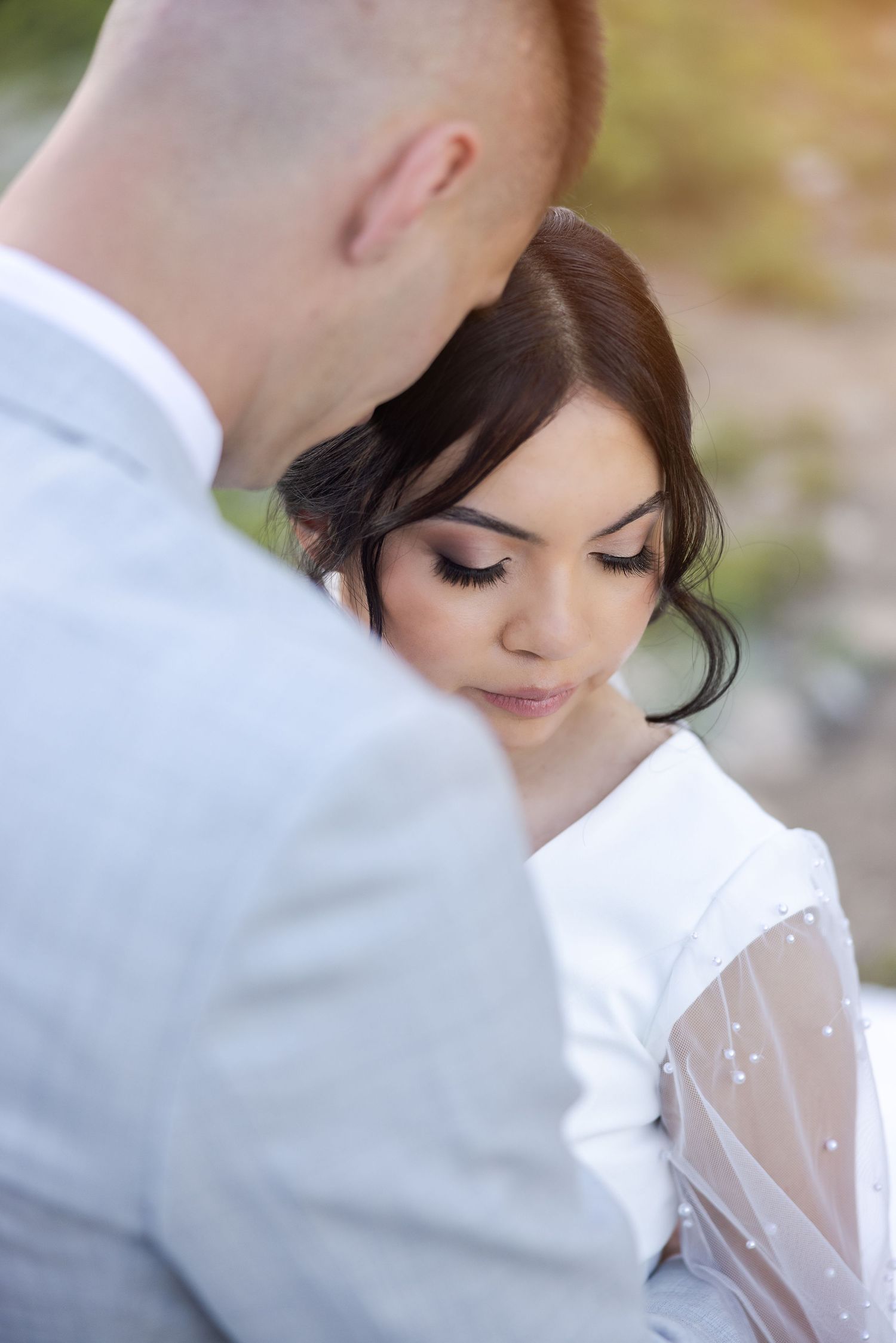 Close-up wedding portrait showing delicate lace details and soft romantic lighting.