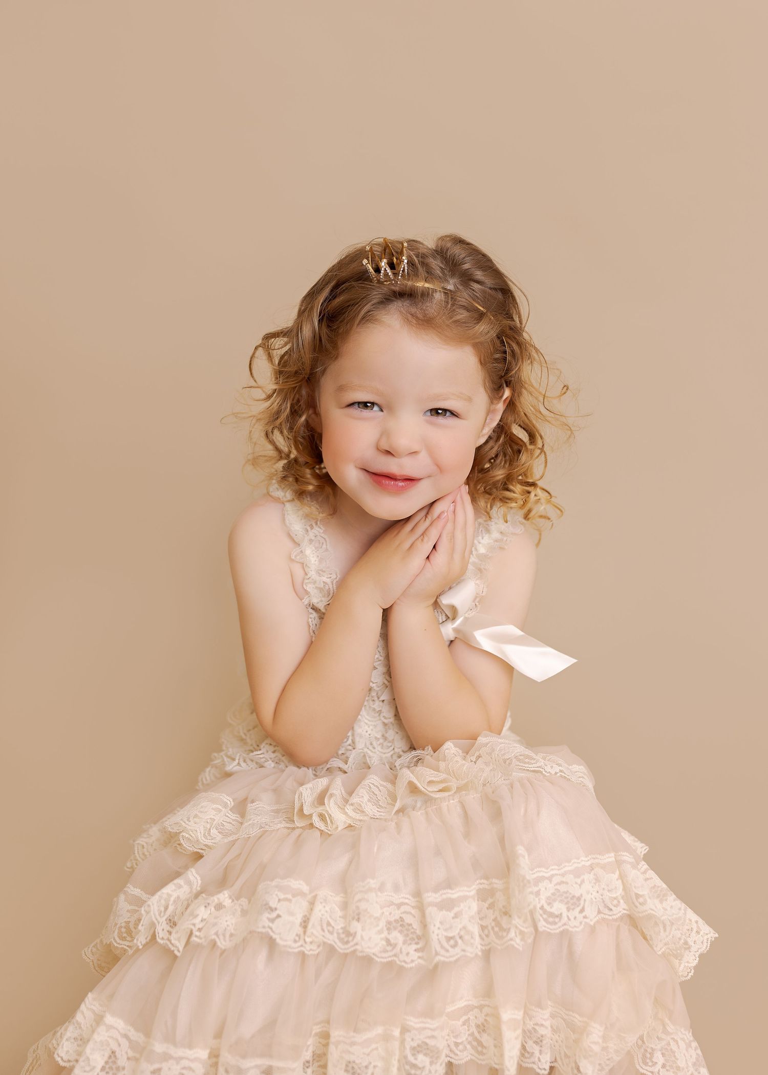 A soft pink vintage-style dress with lace trim and ruffles shown against a neutral backdrop.