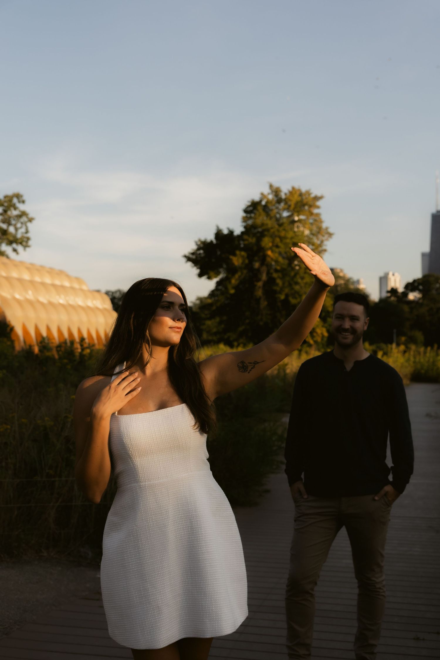 Romantic sunset silhouettes of a couple embracing against an urban skyline backdrop.