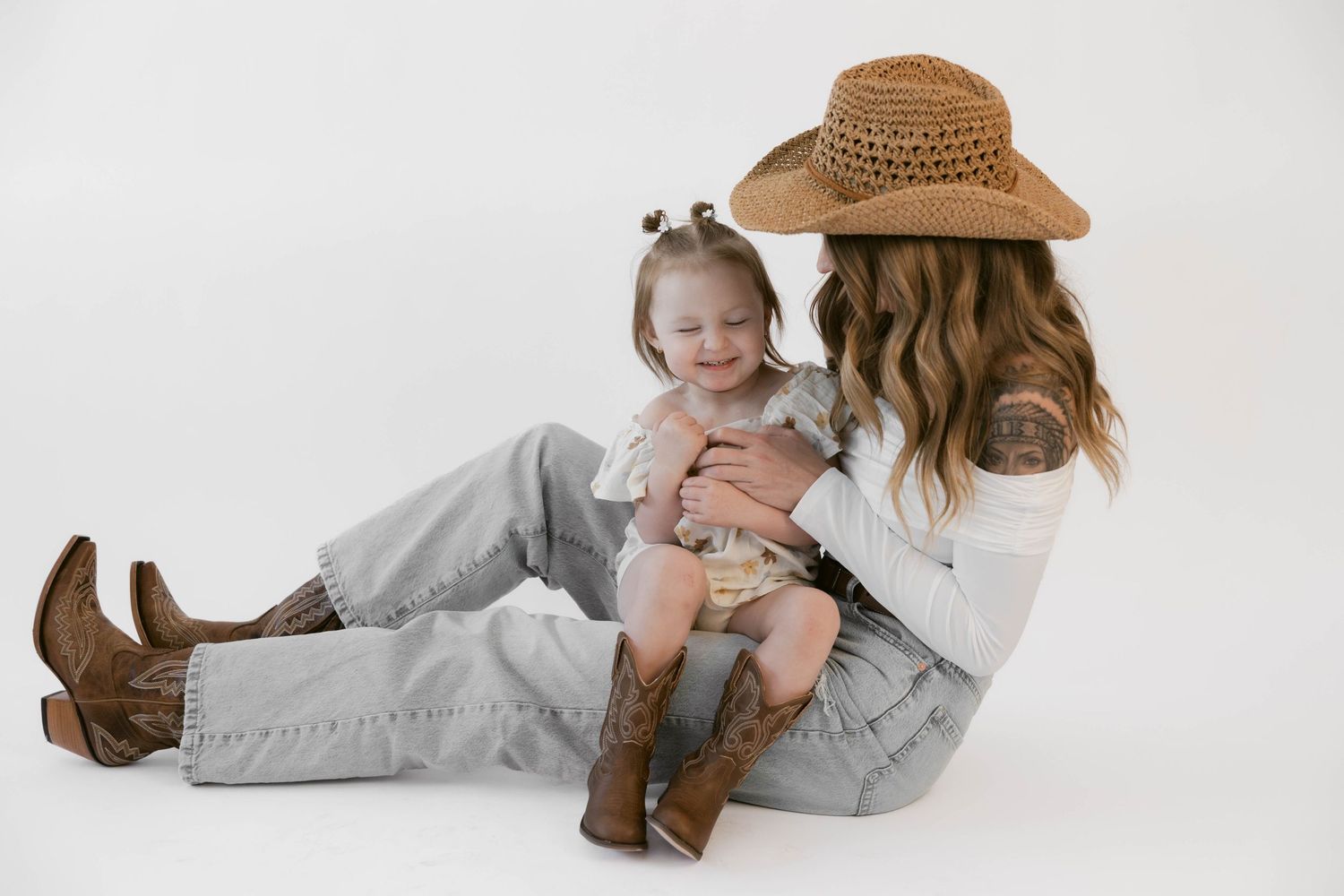 Candid western-styled photo session shows playful interactions on white background.