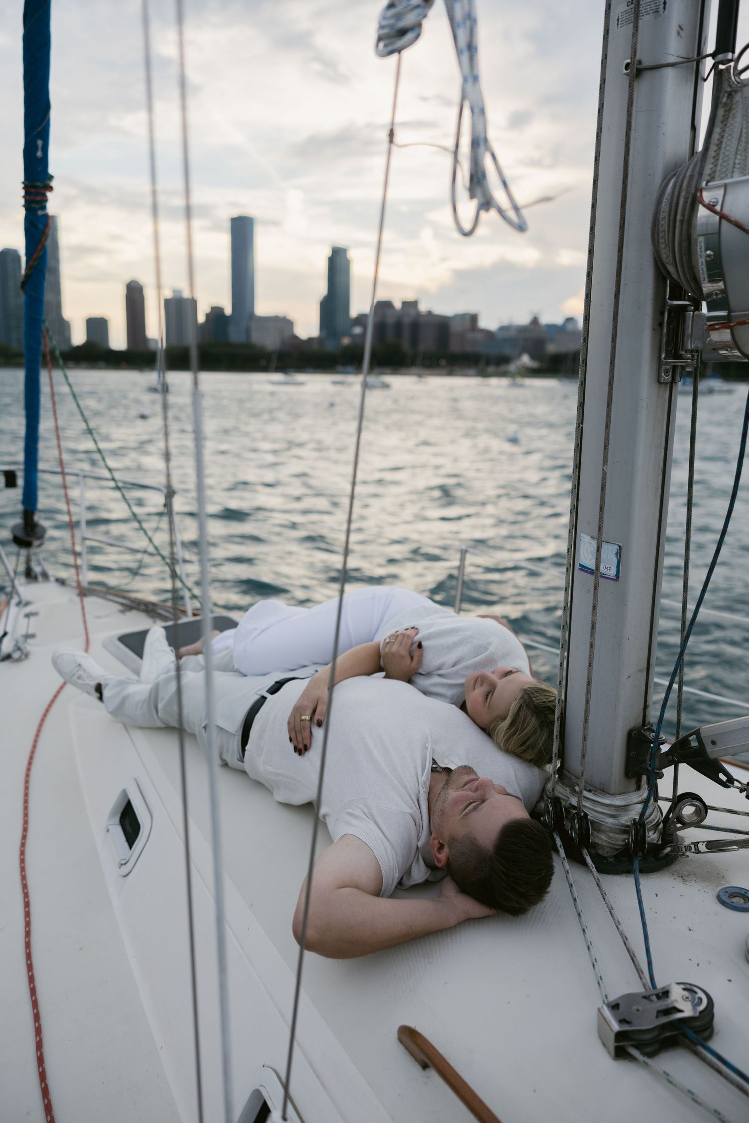 Three consecutive shots of someone lounging on a sailboat deck against cloudy skies.