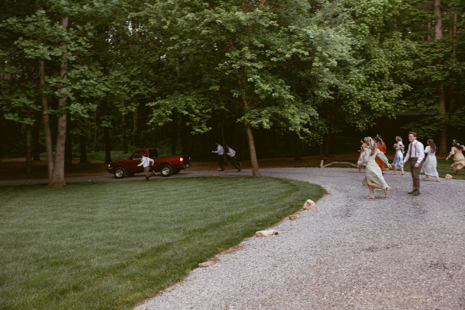 Peaceful wooded outdoor wedding venue with gravel path and green trees.