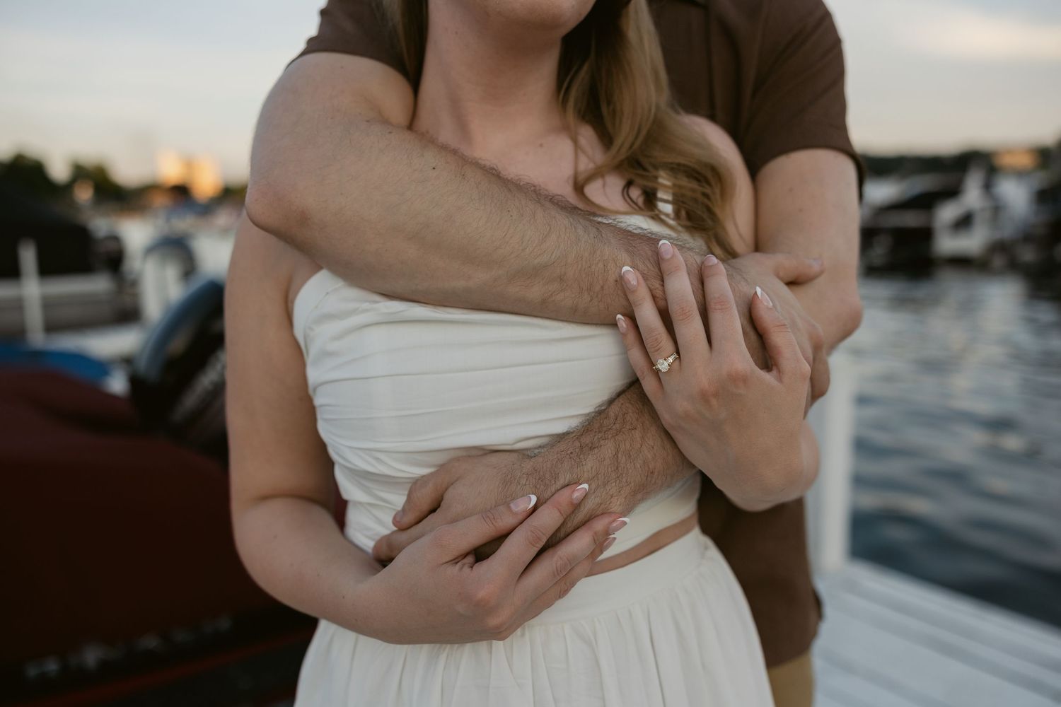 Close-up romantic embrace shot of a couple during a waterfront photoshoot.