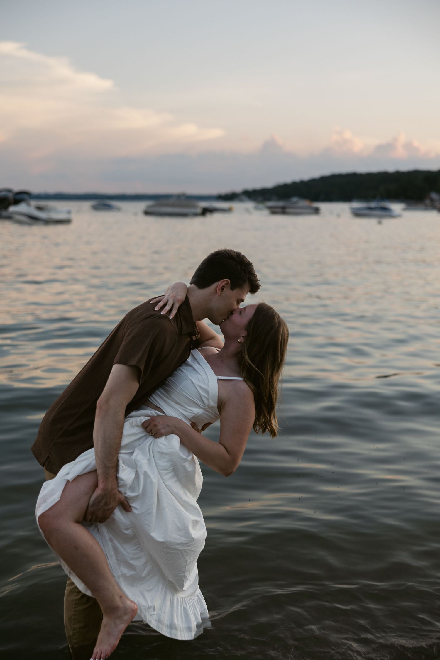A romantic dip pose captured during a waterfront photoshoot at sunset.