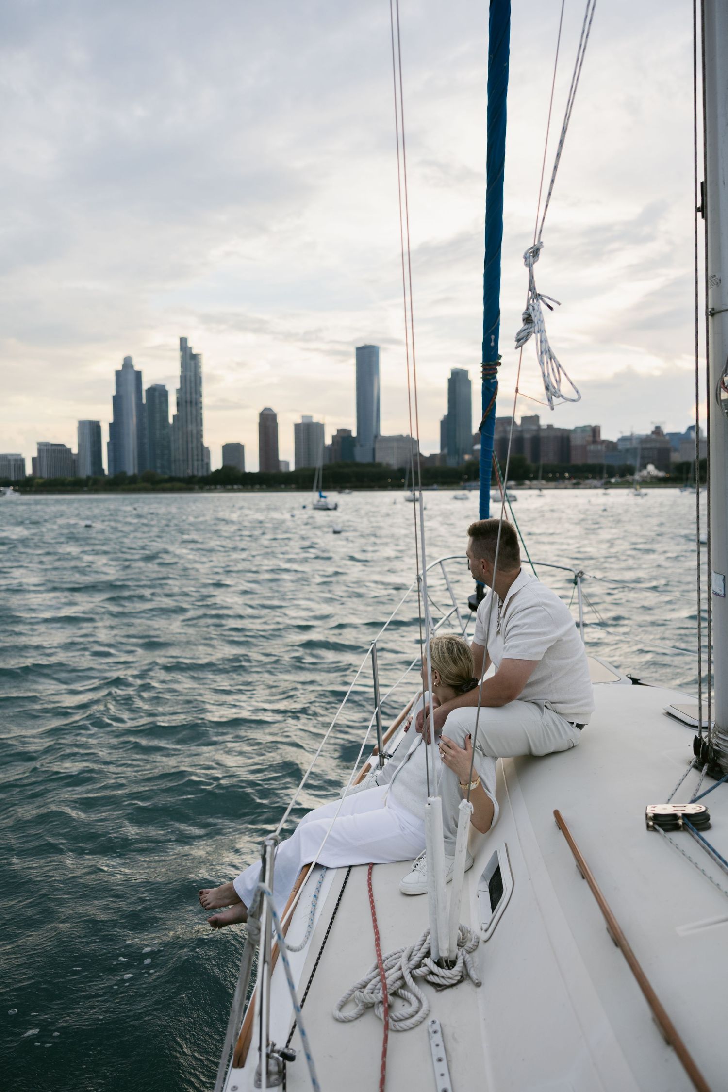 Sailboat deck view with Chicago skyline and choppy waters in background.