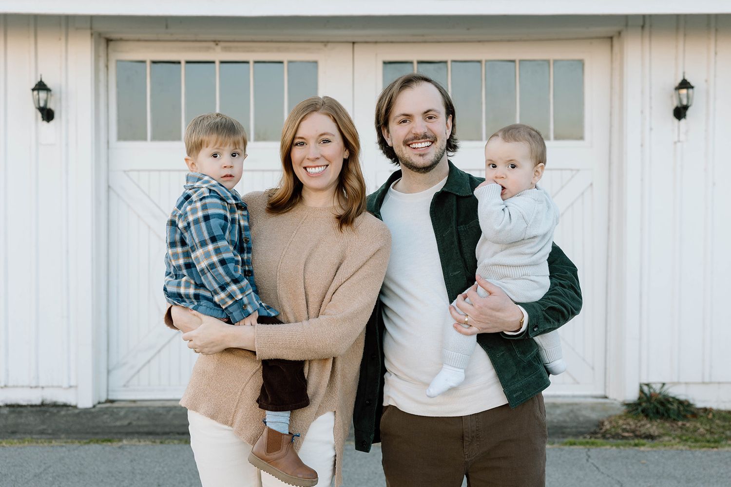 FAMILY POSED PHOTO IN FRONT OF A WHITE BARN