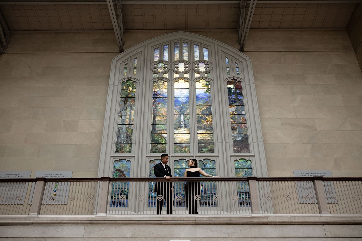 An elegant balcony with arched stained glass windows in a classical architectural setting.