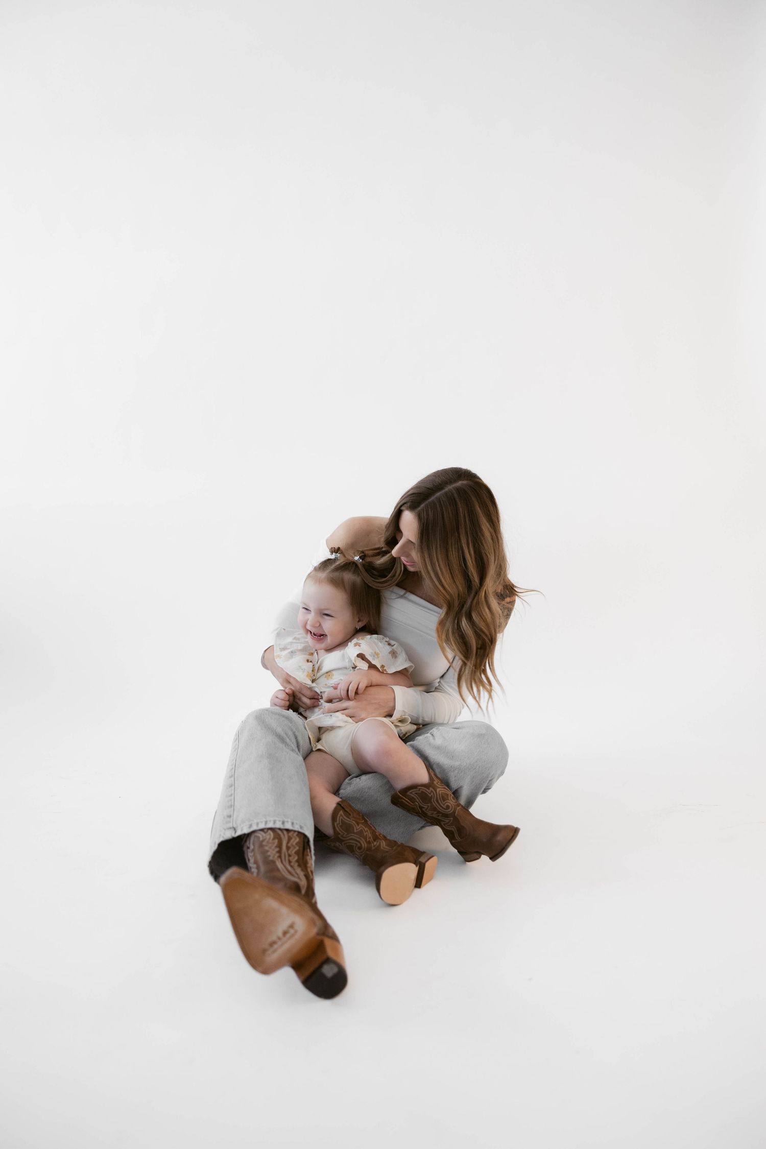 Intimate family portraits showing joyful moments between adult and child on white backdrop.