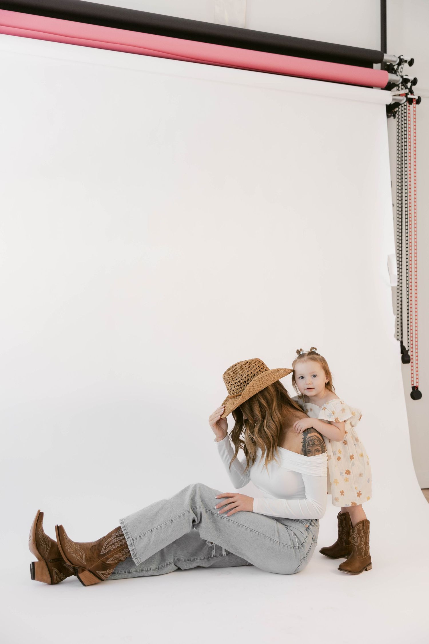 Studio portrait series showing playful interaction with brown boots and light background.