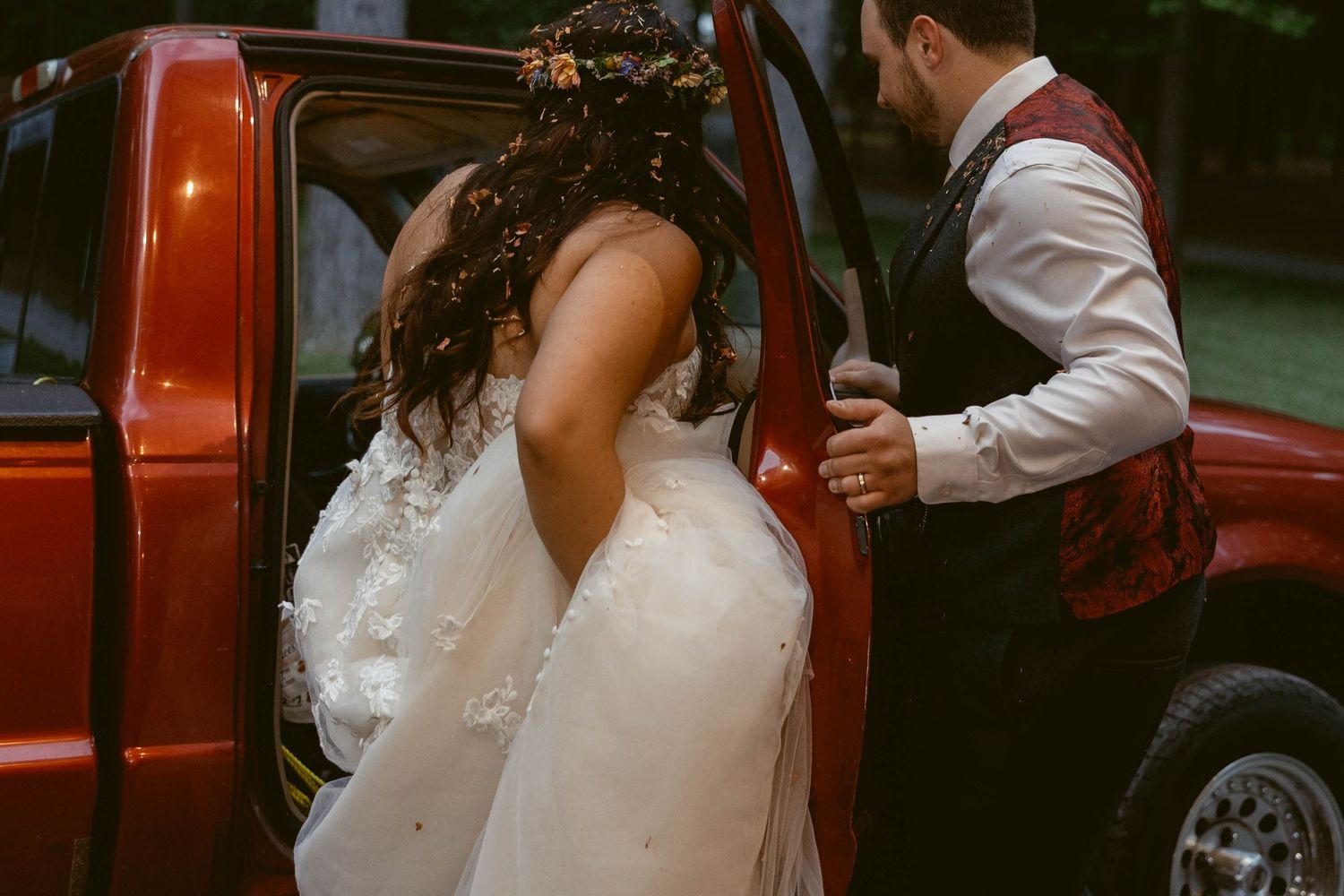 White wedding dress detail against red vintage truck backdrop.