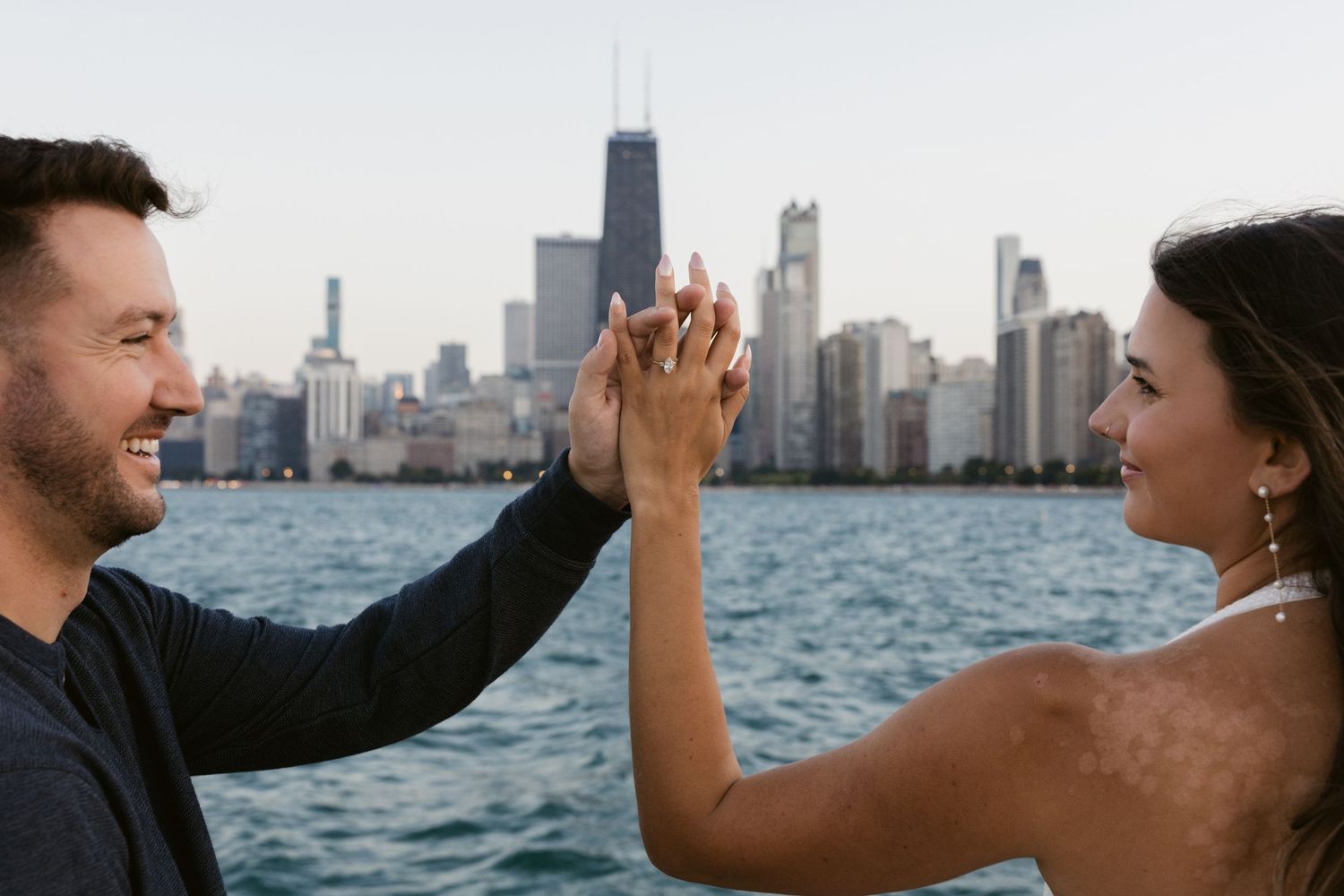 Happy couple celebrating with high five against Chicago cityscape.