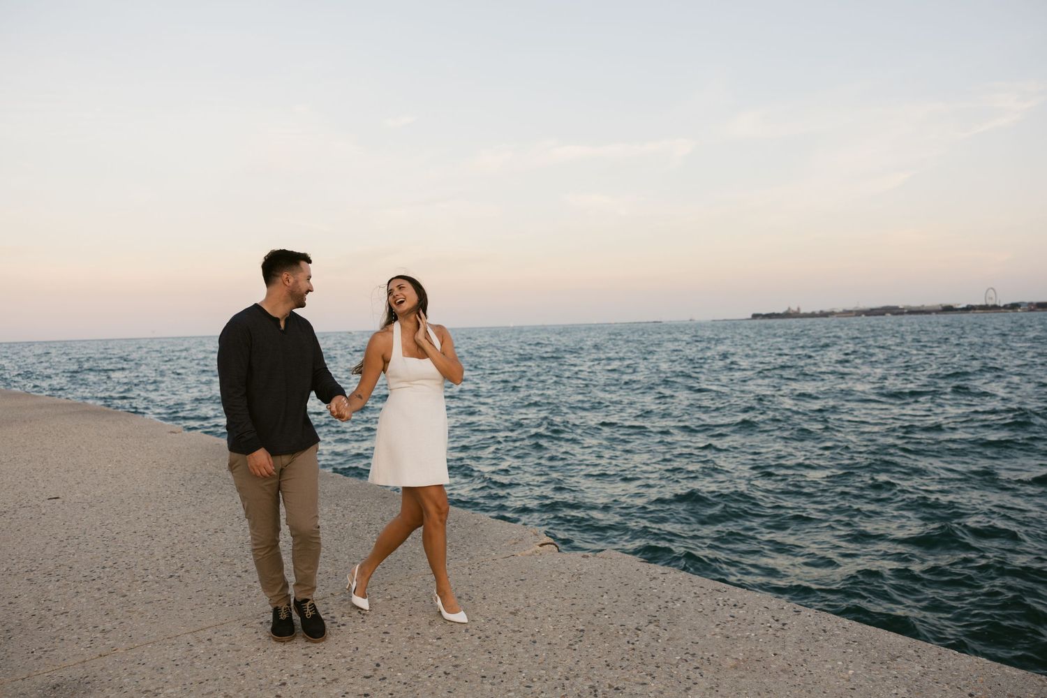 Couple walking along Lake Michigan with Chicago's iconic skyline in the background.