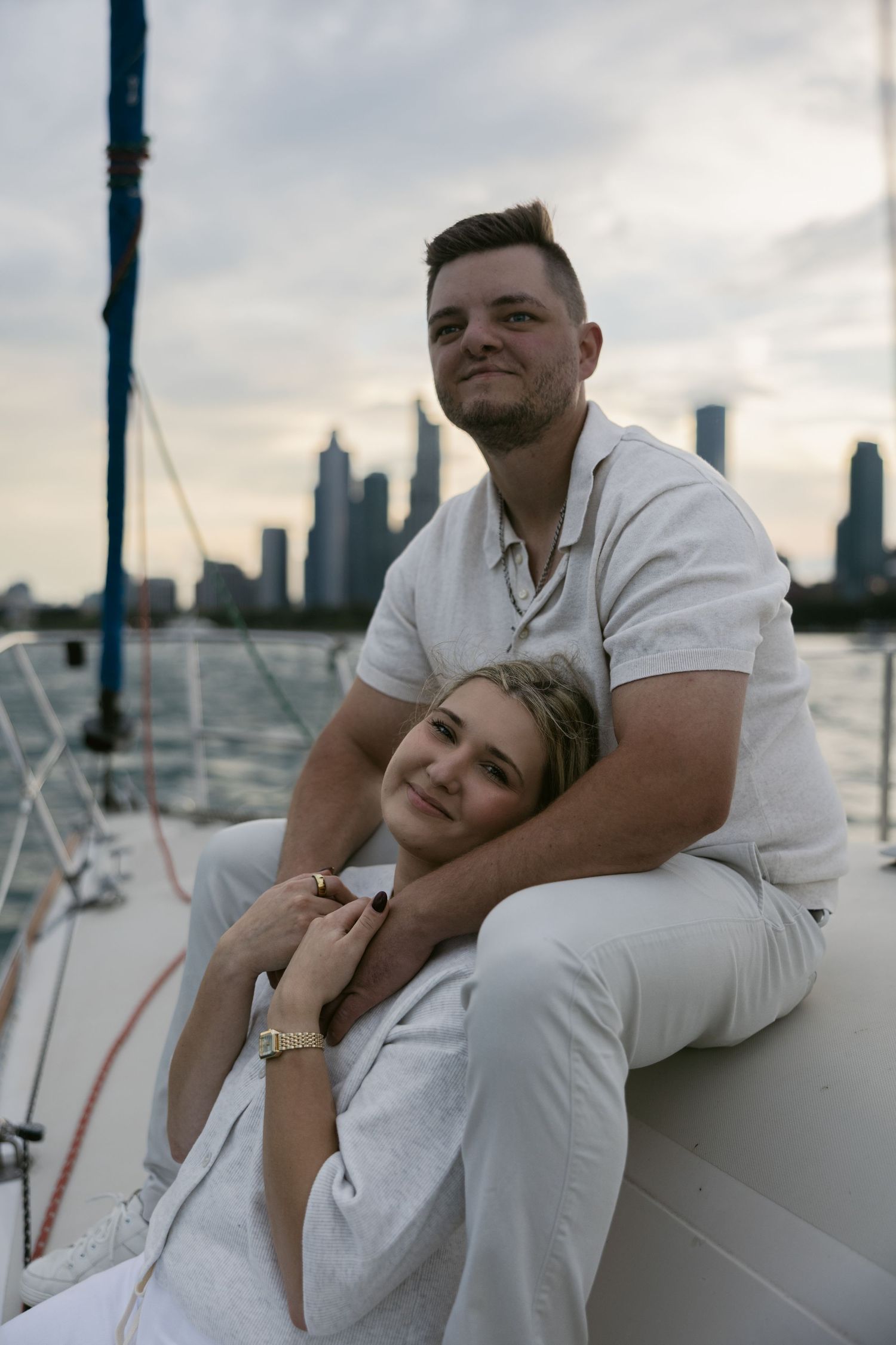 Intimate couple portraits captured on yacht deck with urban waterfront backdrop.