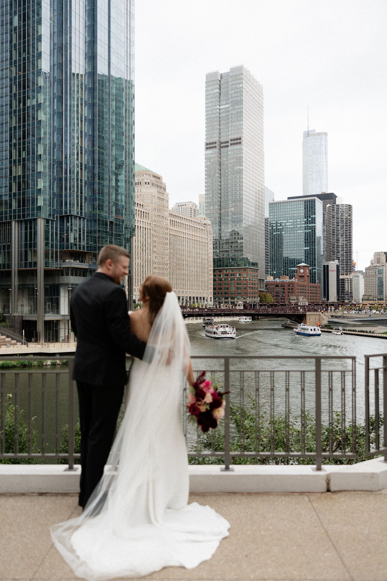A couple shares romantic wedding photos against the stunning Chicago skyline and river backdrop.