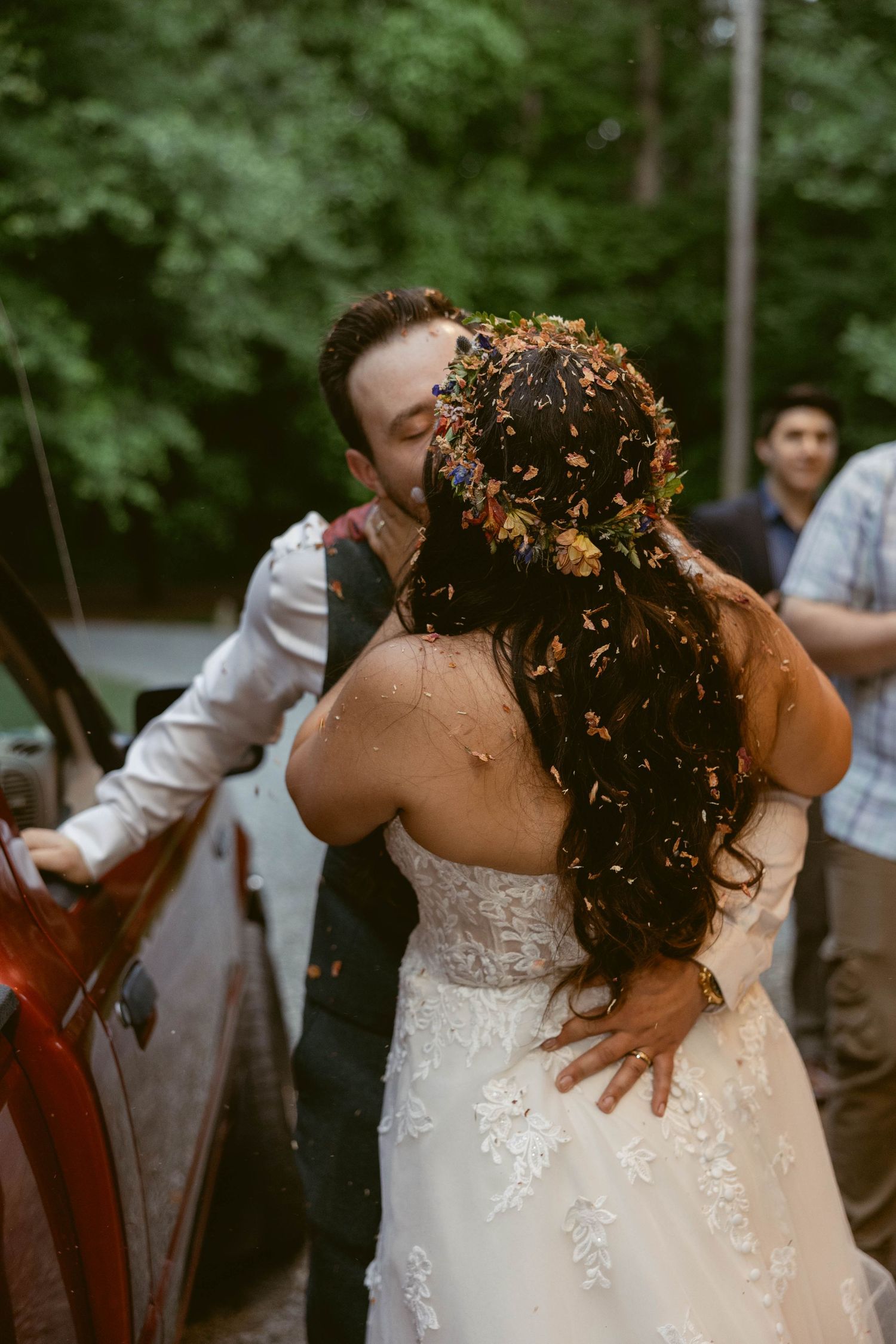 Elegant lace wedding dress detail shown during outdoor celebration.