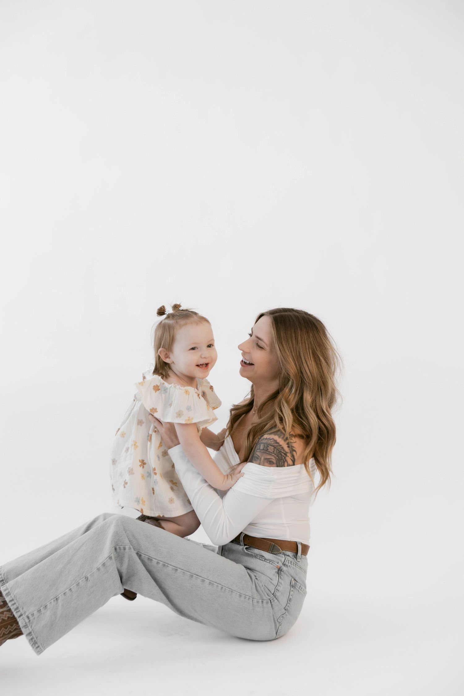 Two people share genuine laughter during casual studio portrait session.