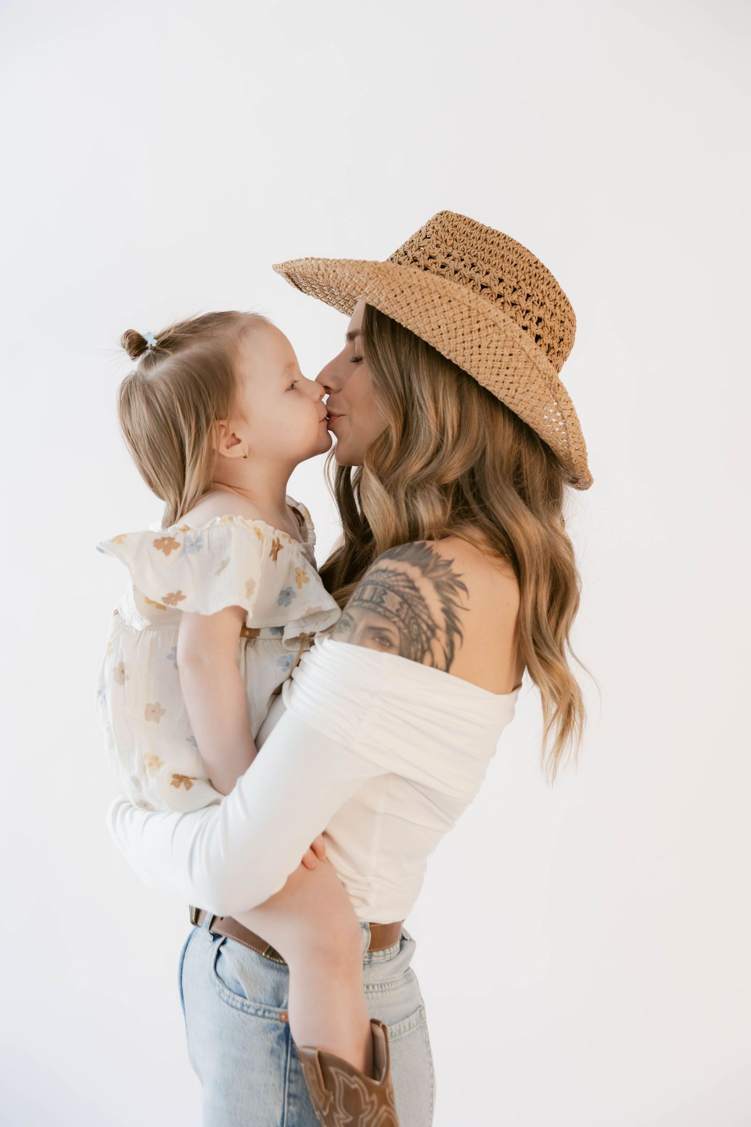 Tender moment captured during lifestyle portrait session with western-inspired styling.
