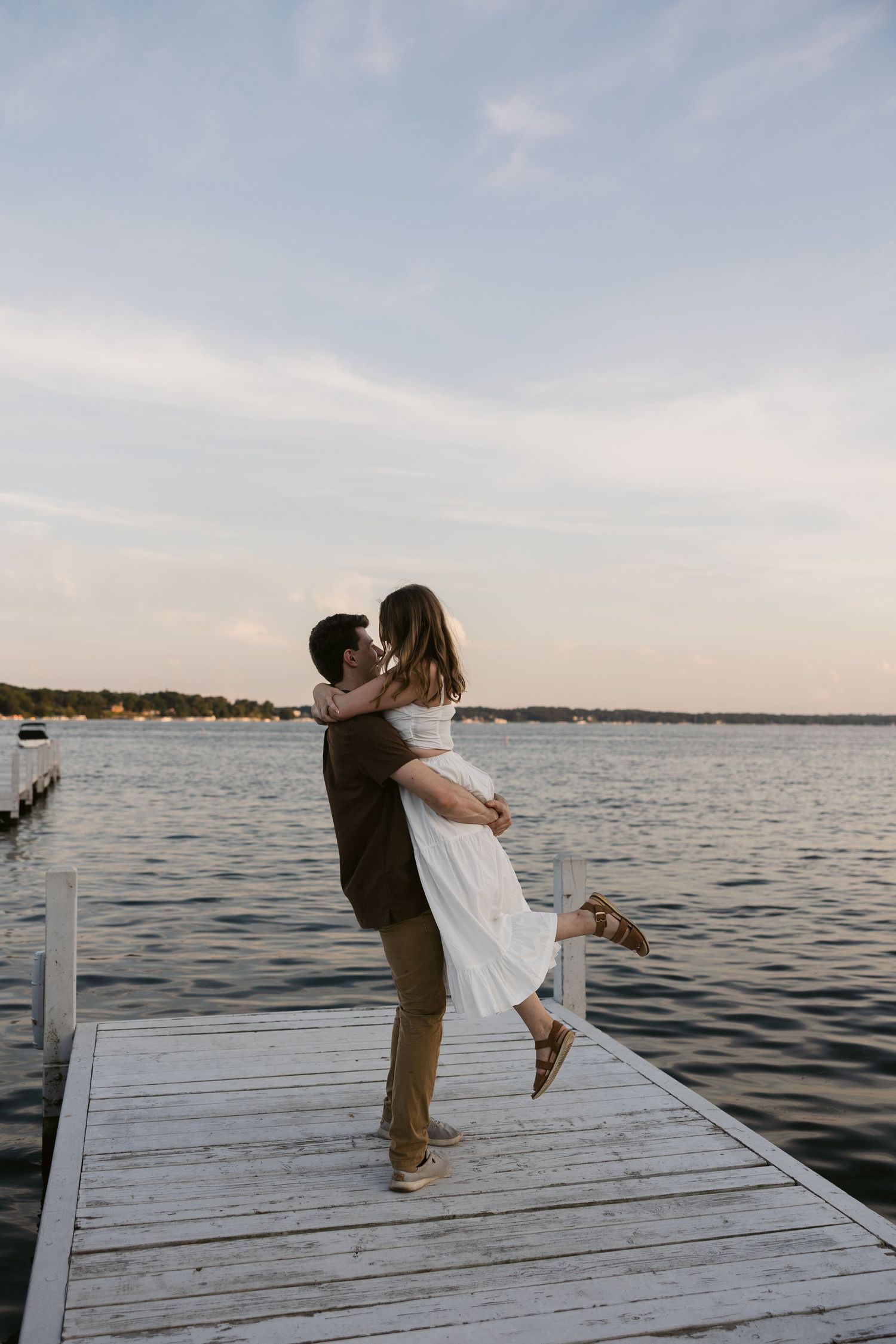 A romantic dance sequence on a lakeside dock during golden hour.