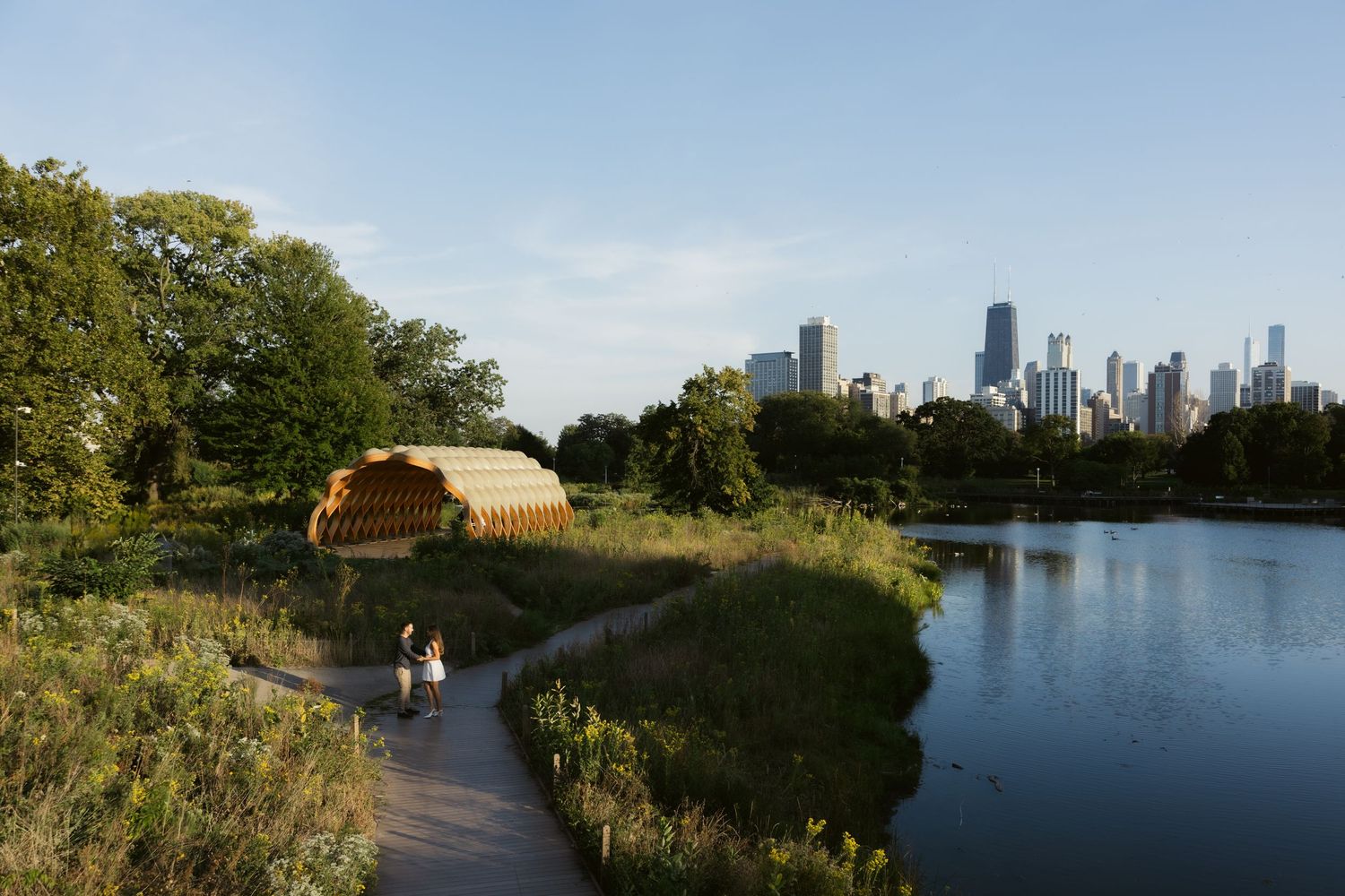 A curved pathway along Lincoln Park's North Pond with the Chicago skyline visible in the background.