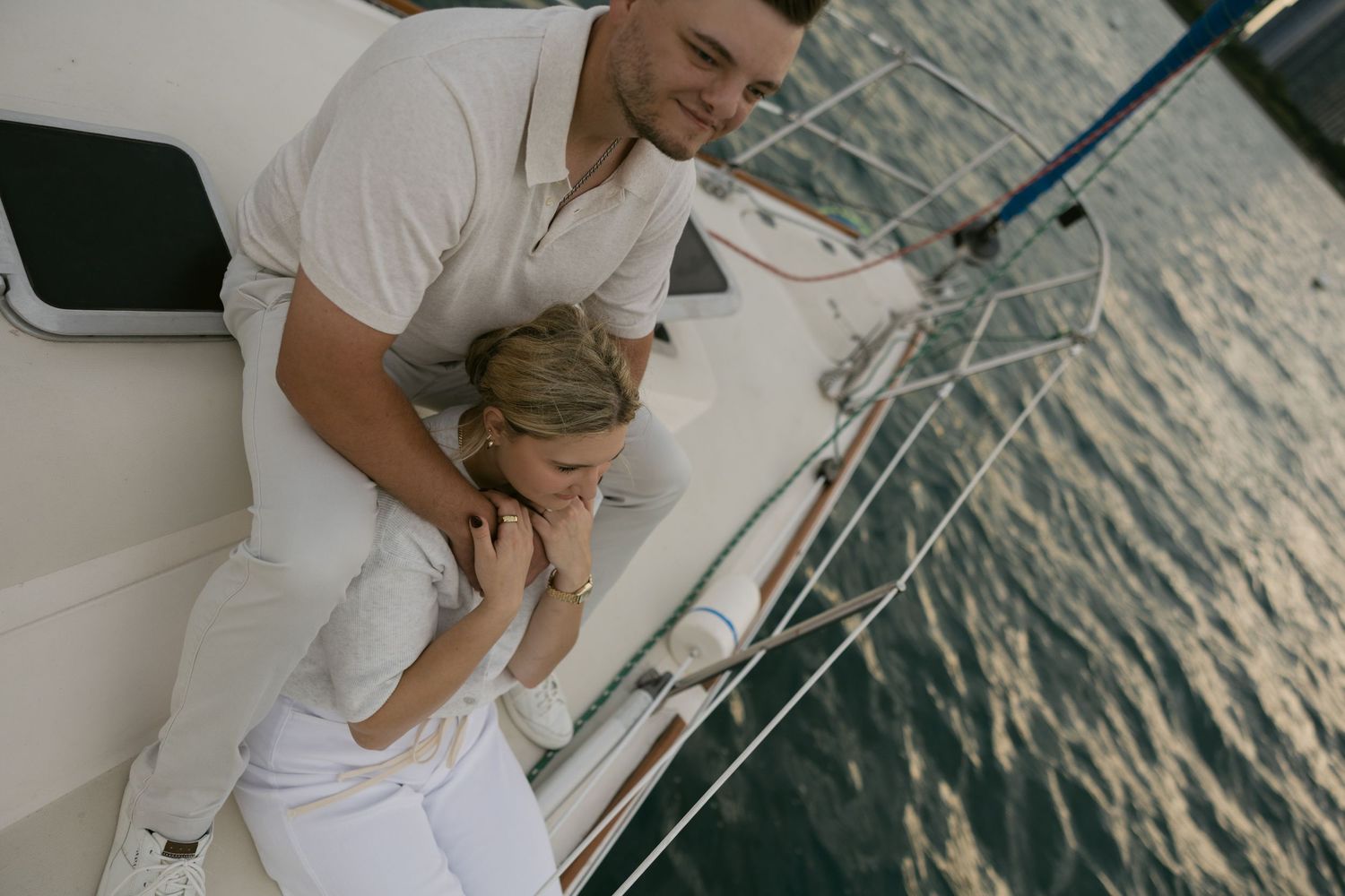 Intimate moments captured on a sailboat during sunset with water reflections in view.