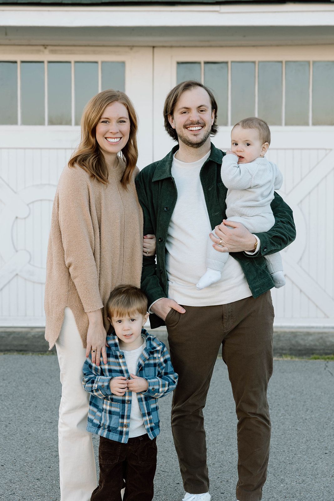 FAMILY POSED PHOTO IN FRONT OF A WHITE BARN