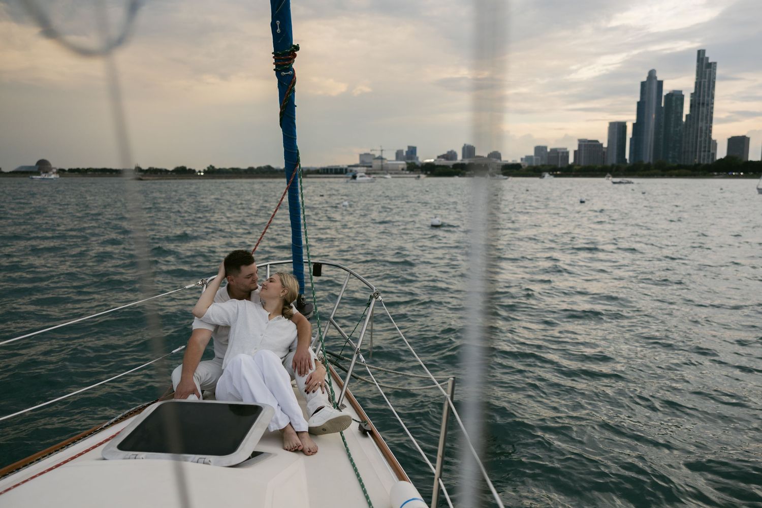 Sailboat passengers enjoy views of the Detroit waterfront at dusk from their vessel.