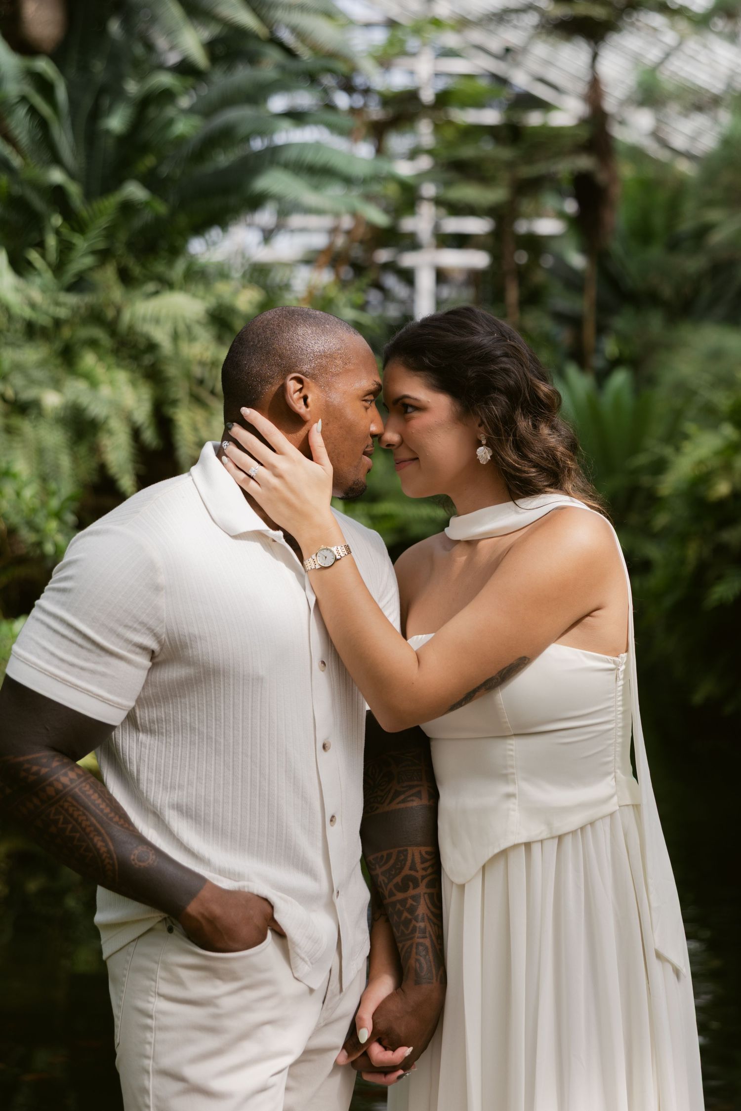 A tender moment captured in multiple frames showing a romantic couple in white attire embracing amidst lush greenery.