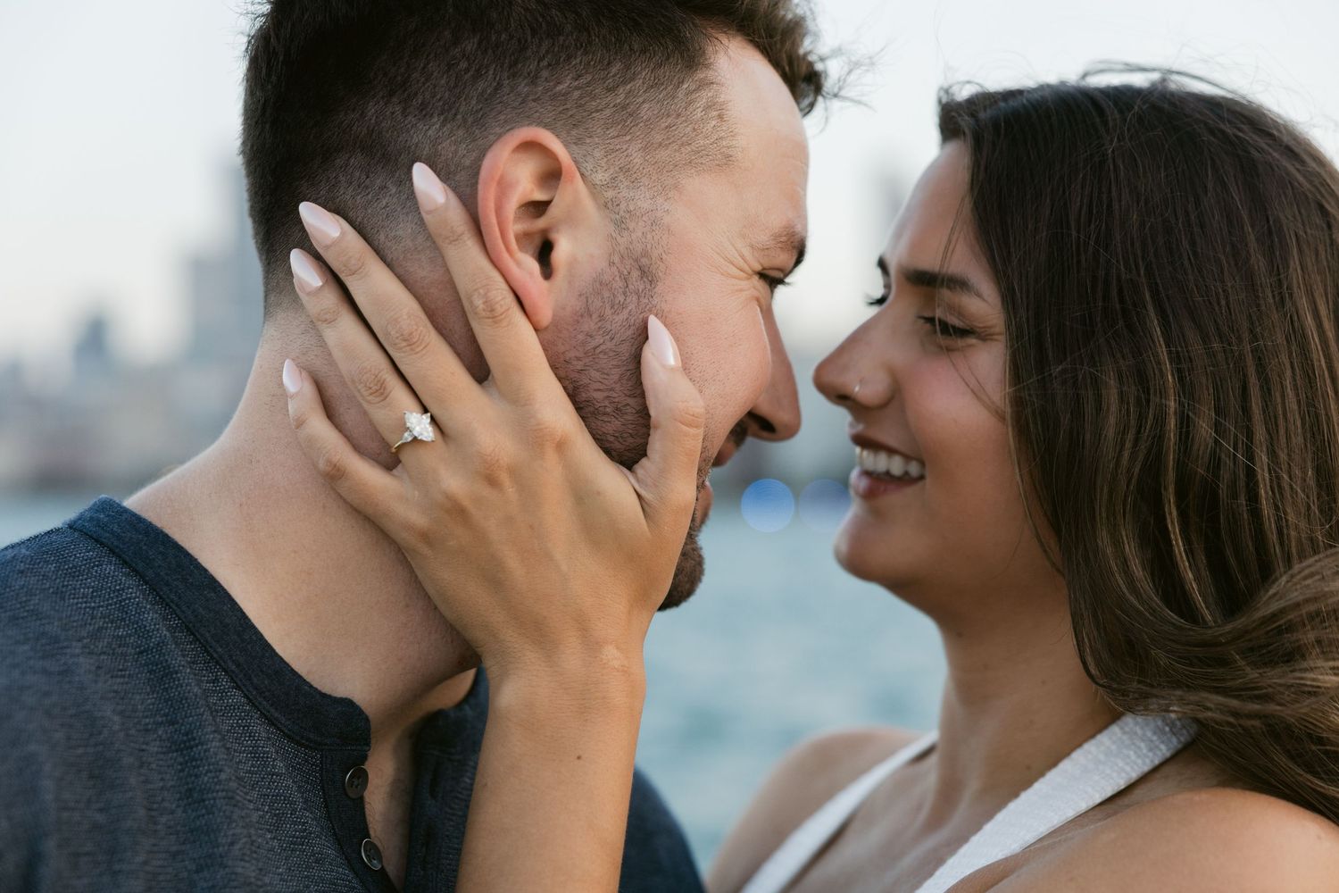 Intimate moment between couple with Lake Michigan and urban skyline in the background.