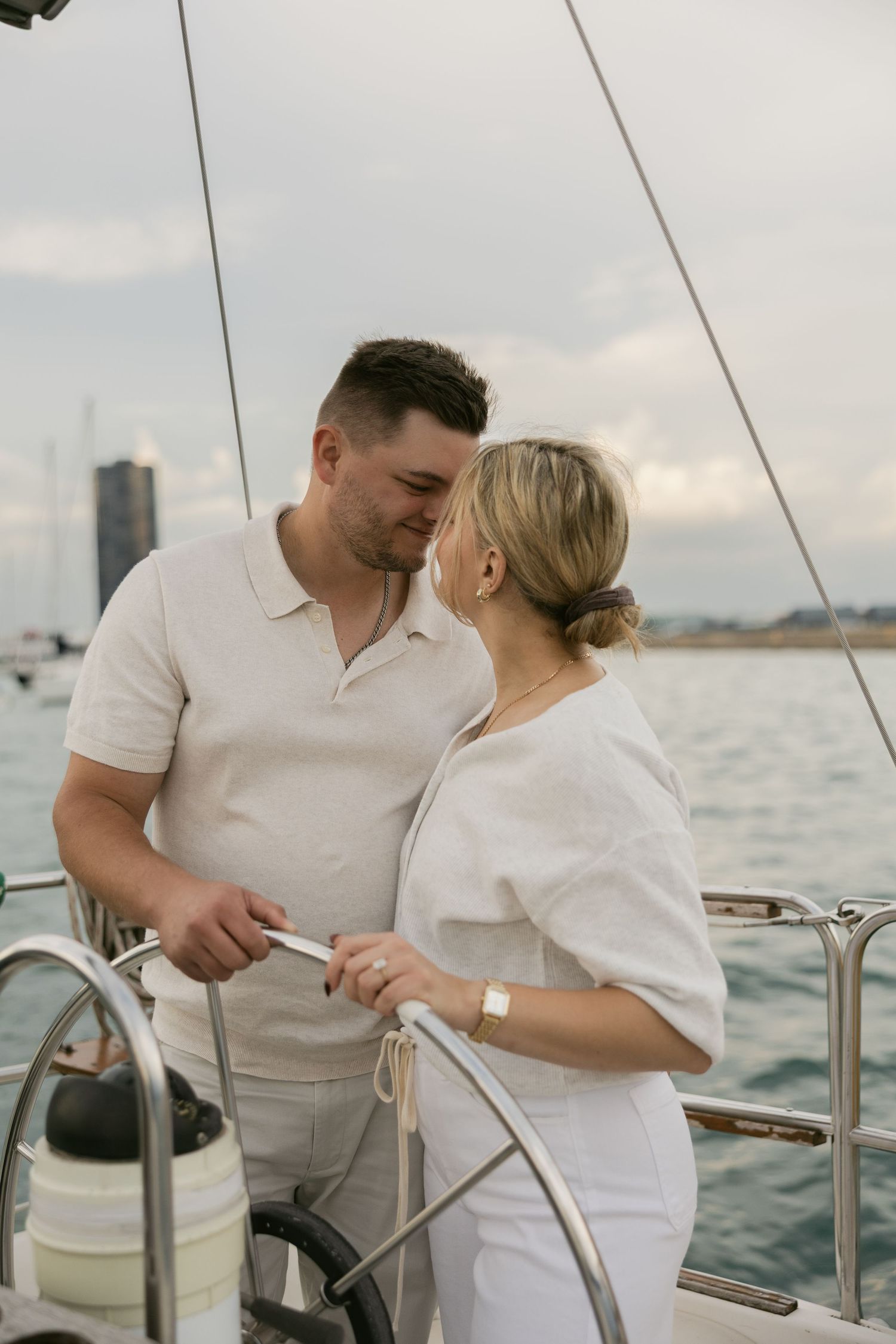 Two people sharing tender moments while sailing on a boat with the Chicago waterfront visible.