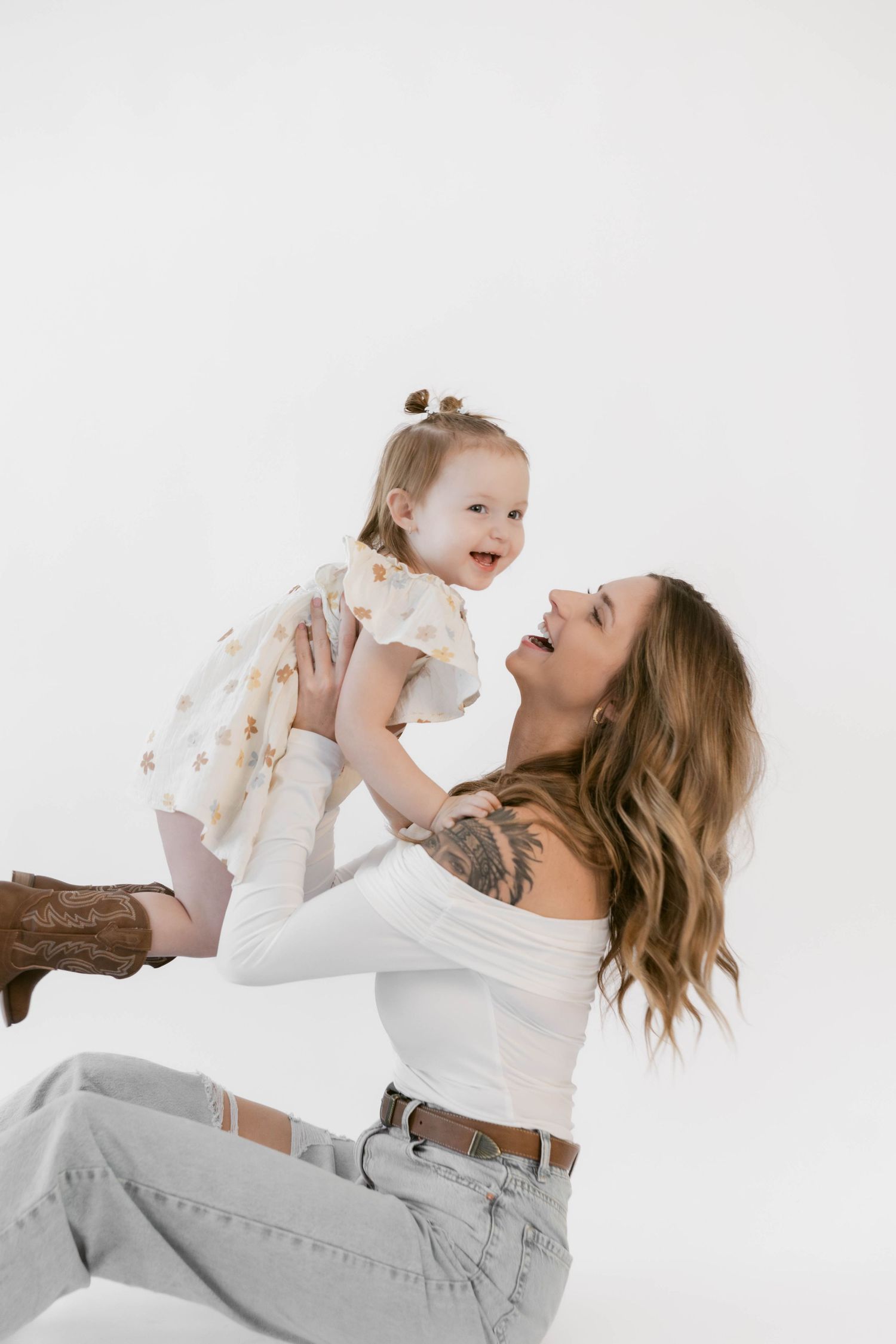 A joyful studio portrait featuring matching western-inspired outfits against white background.