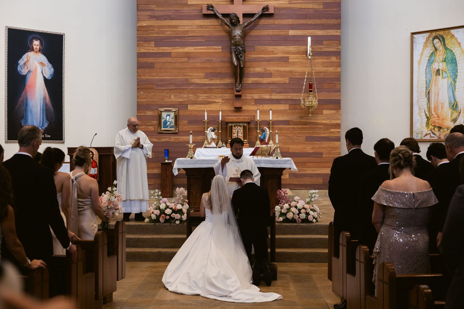 Church wedding ceremony with wooden paneled altar decorated with religious imagery.