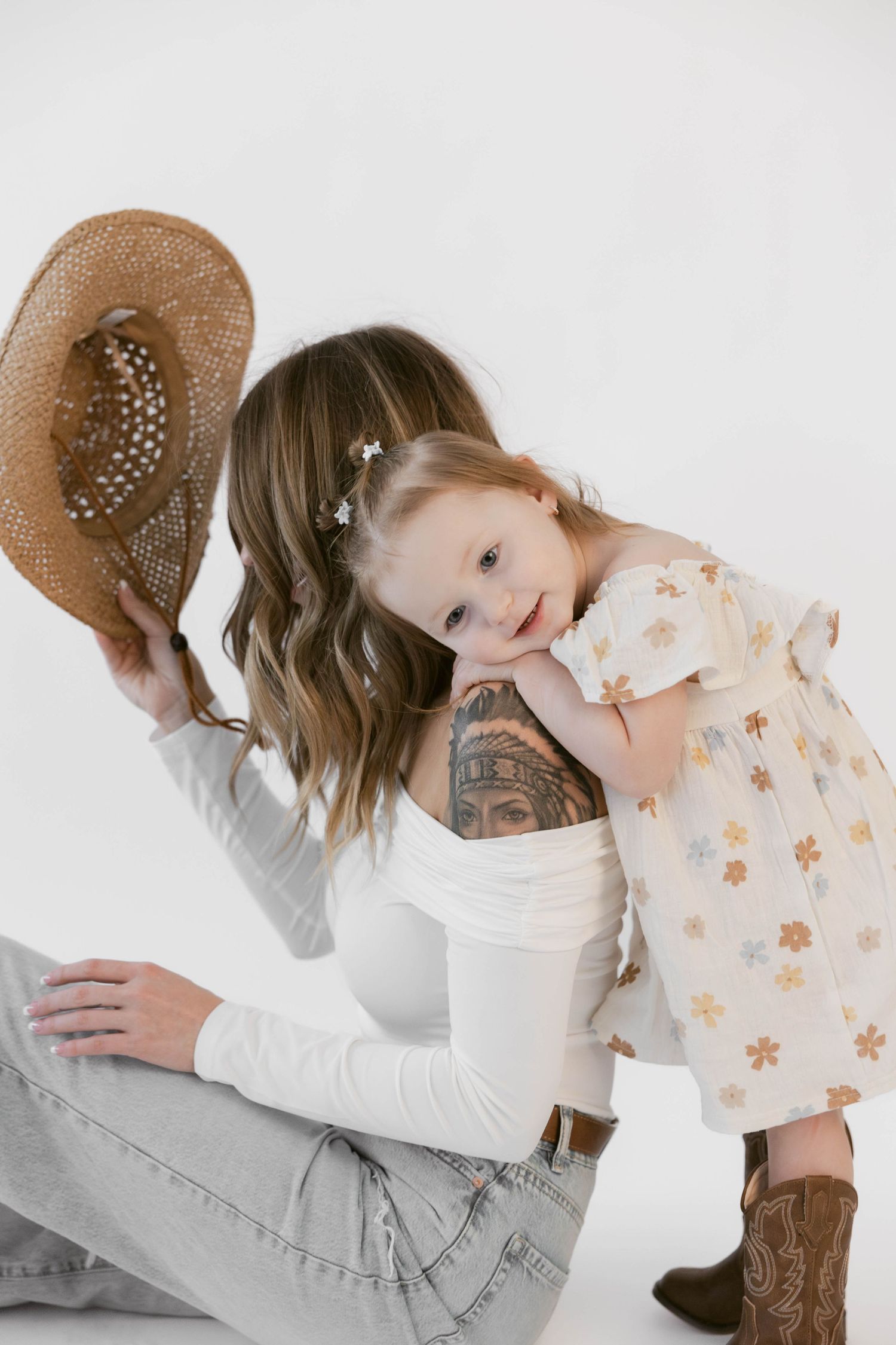 Intimate studio portraits showing gentle moments between parent and child in western attire.