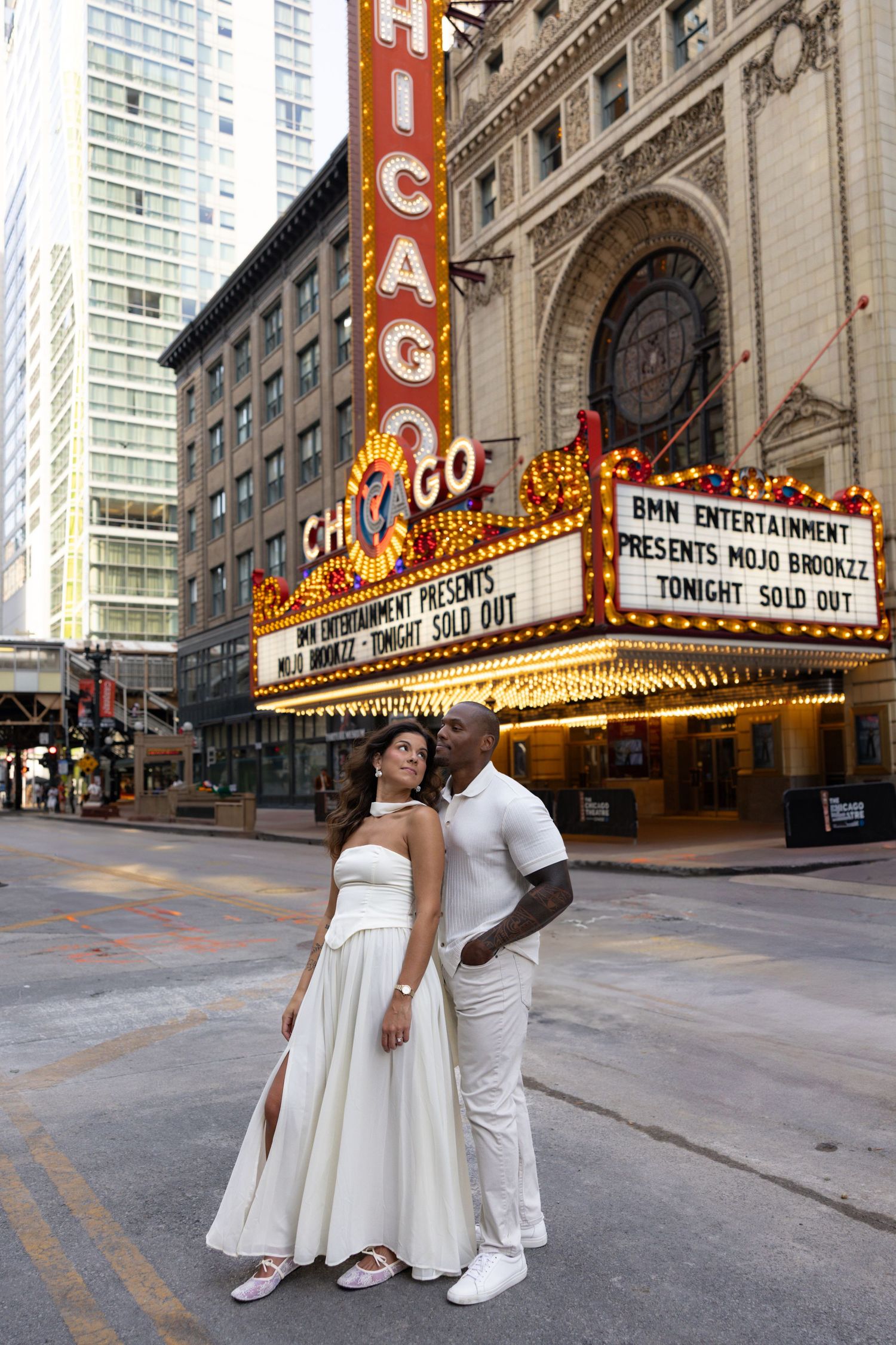 Wedding photos outside historic Chicago Theatre with illuminated marquee signs.
