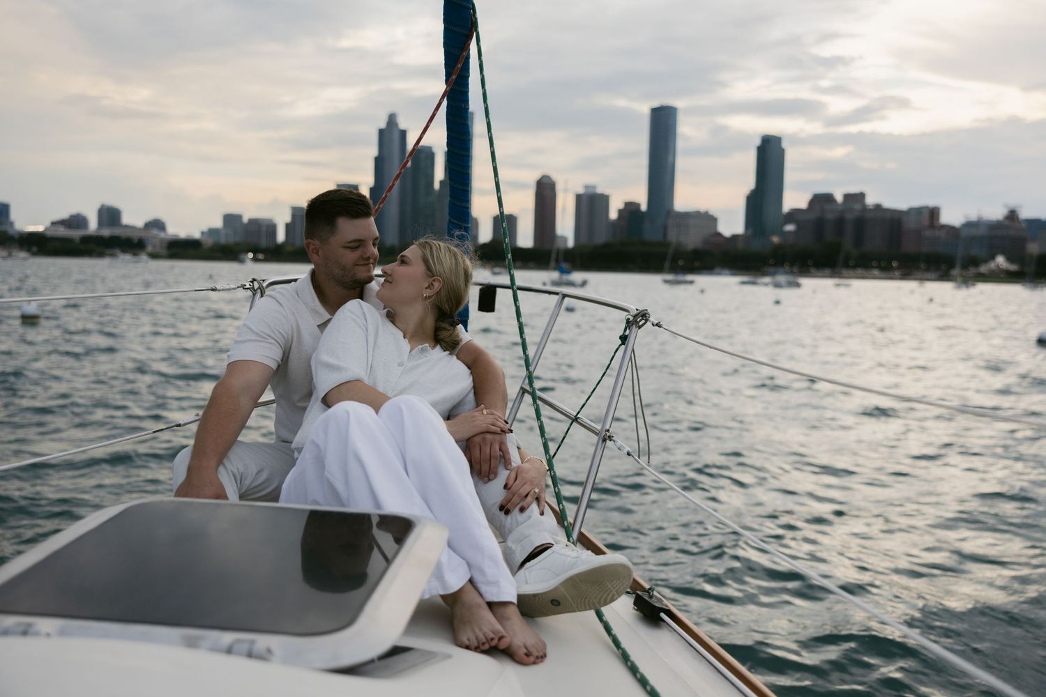 Sailboat deck with city skyline and water views in background.