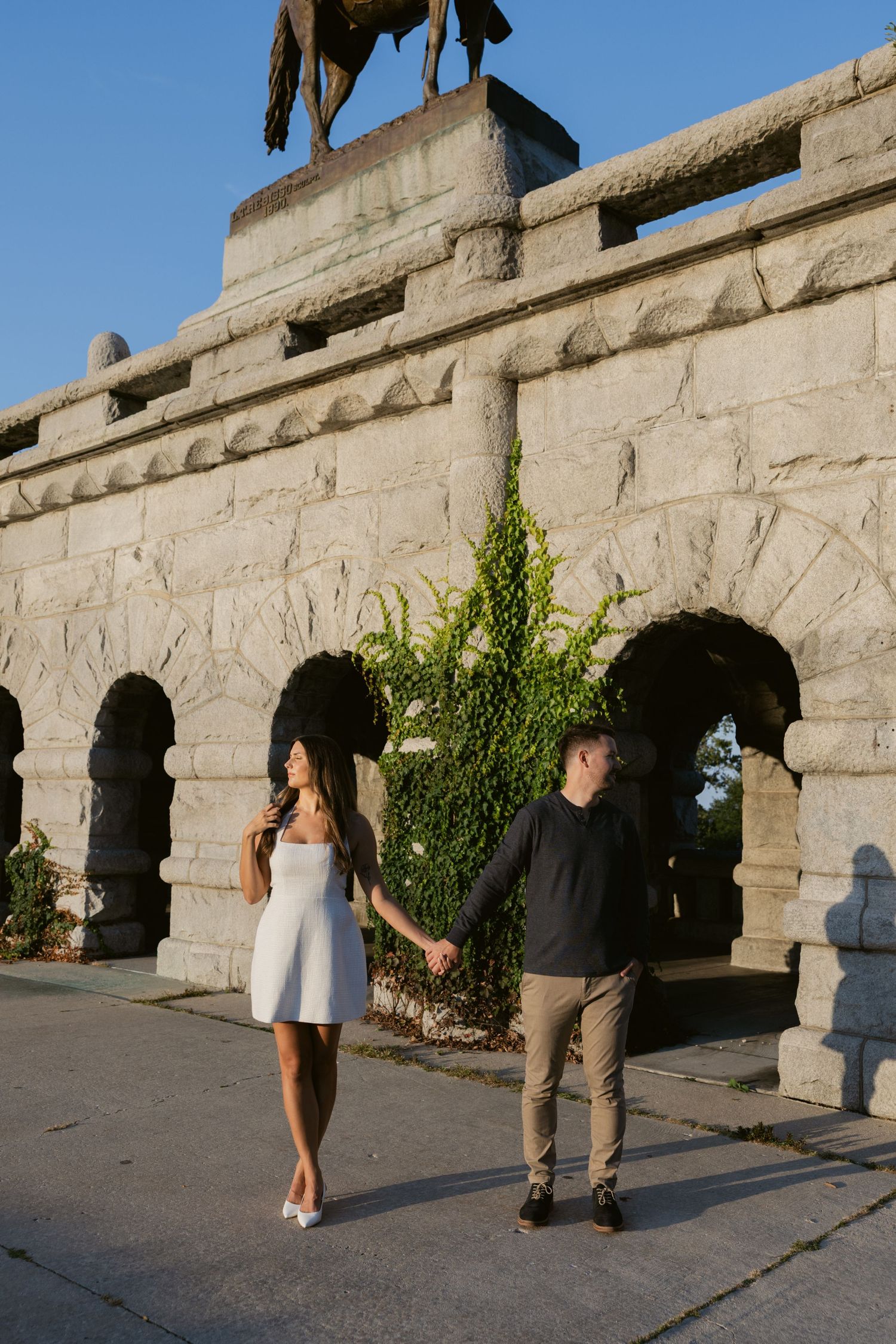 Stone archways of a historic building facade with ivy growing on the walls.