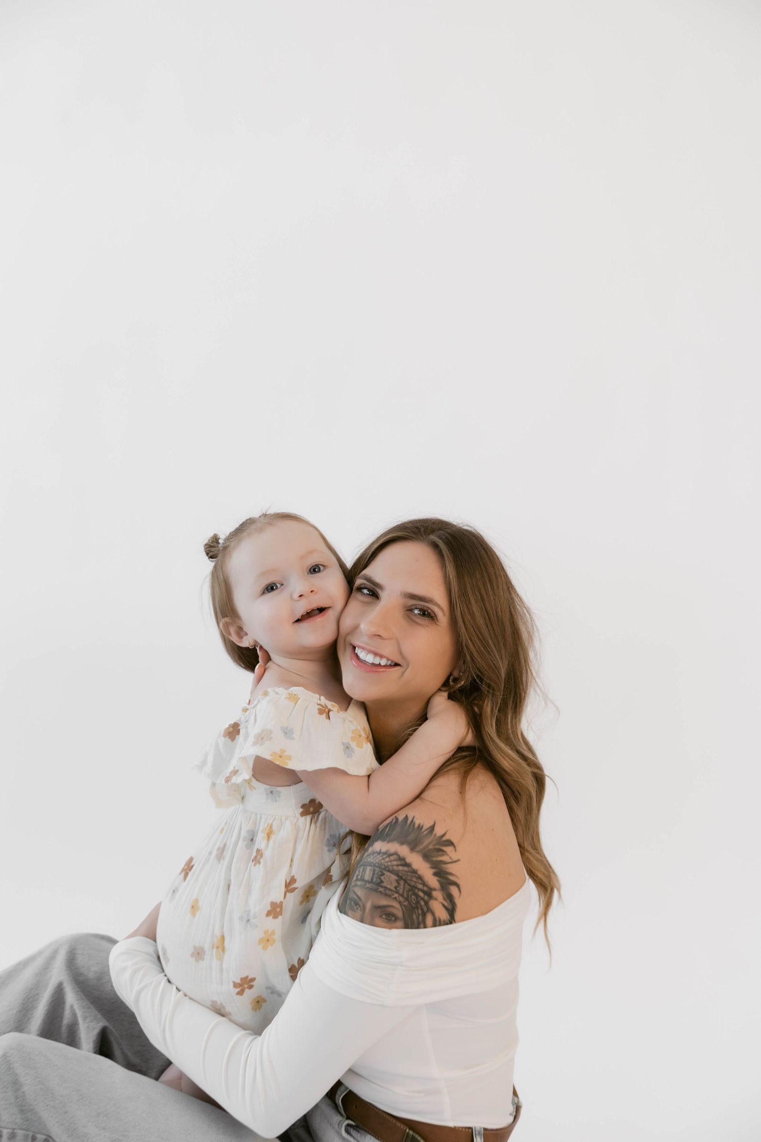 An intimate portrait showing genuine connection during white studio photoshoot.