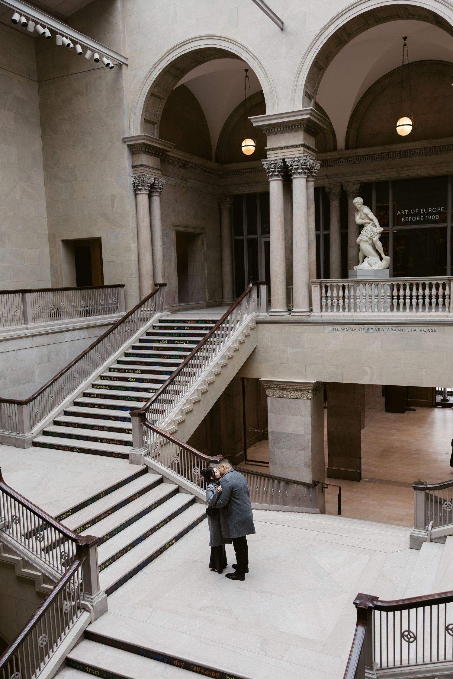 An elegant marble staircase with arches creates a dramatic architectural setting.