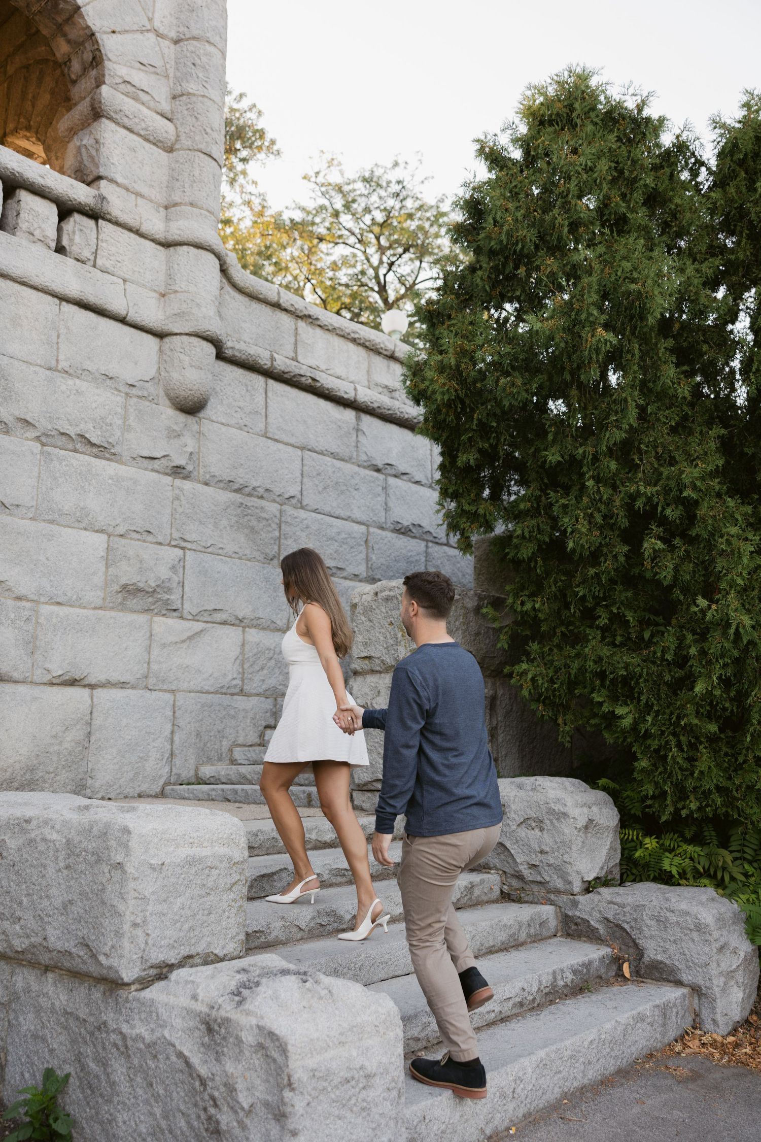 Couple climbing stone steps at a historic stone structure during a photo session.