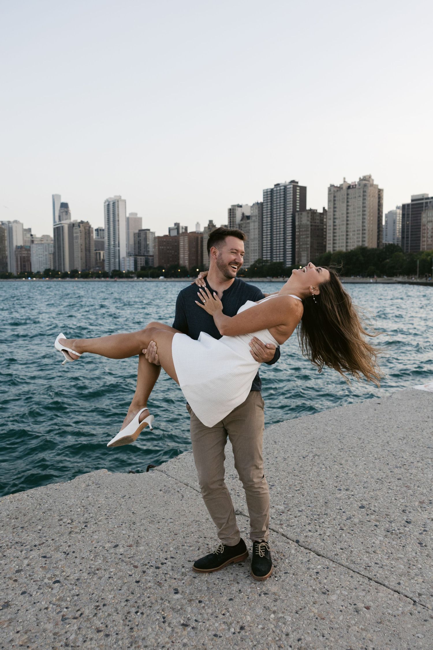 Romantic dip pose on North Avenue Beach with Chicago's dramatic skyline in the background.