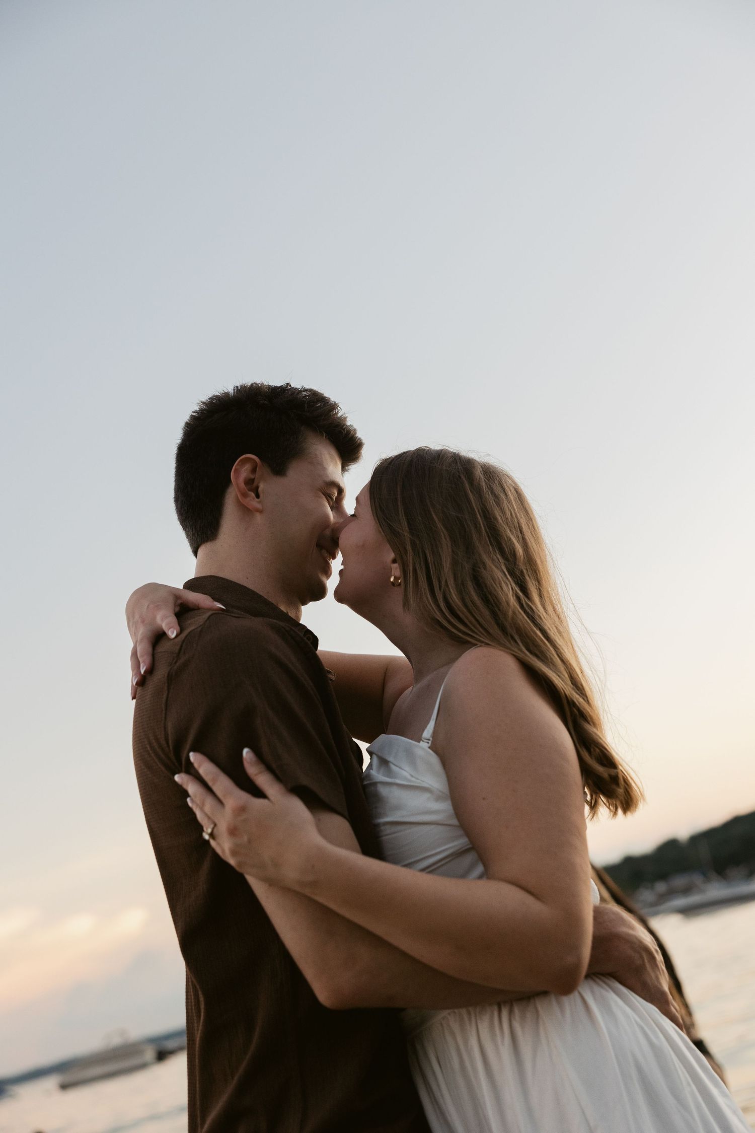 A close-up shot of a couple sharing an intimate moment during their waterfront photo session.